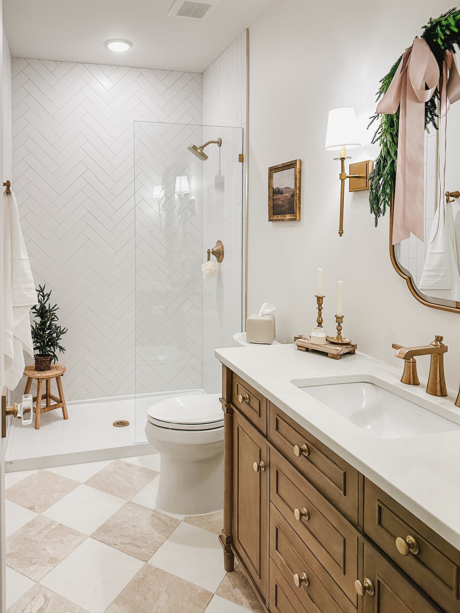 Simple basement guest bathroom Christmas views with faux greenery and pops of pink ribbon! Loving this vanity from Home Depot - I swapped out the pulls for gold knobs! 

Bathroom views, neutral home, style inspo, gold detail, cozy Christmas vibes, checkered tile floor, faux greenery, ribbon detail, lighting detail, creamy whites, warm wood, pops of pink, holiday views, gold knob, mirror finds, neutral bathroom aesthetic, light and bright, Home Depot, found it on Amazon, furniture faves, wooden stool, Wayfair, Target home, gold fixtures, shop the look!

#LTKhome #LTKHoliday #LTKSeasonal