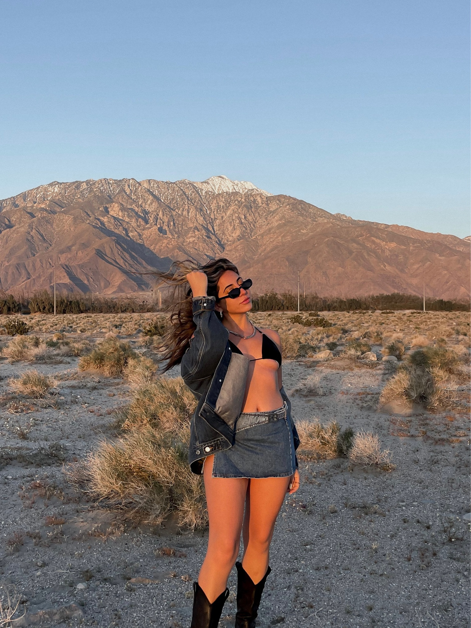 Dark denim jacket, black sunglasses, silver hoops, silver chunky chain necklace, black cowboy boots, western boots, black bikini top, denim slit skirt, festival style 

#LTKFestival #LTKSeasonal #LTKstyletip