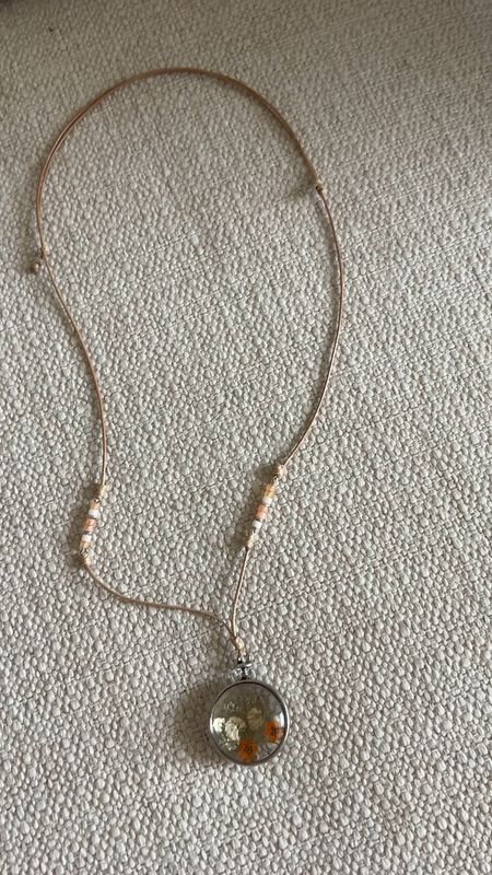 Pendant necklace. Dainty flowers. Thin leather strap. Tiny beads. Earthy and feminine. Style with a tank top and denim jacket. 

#LTKfindsunder50 #LTKstyletip #LTKover40