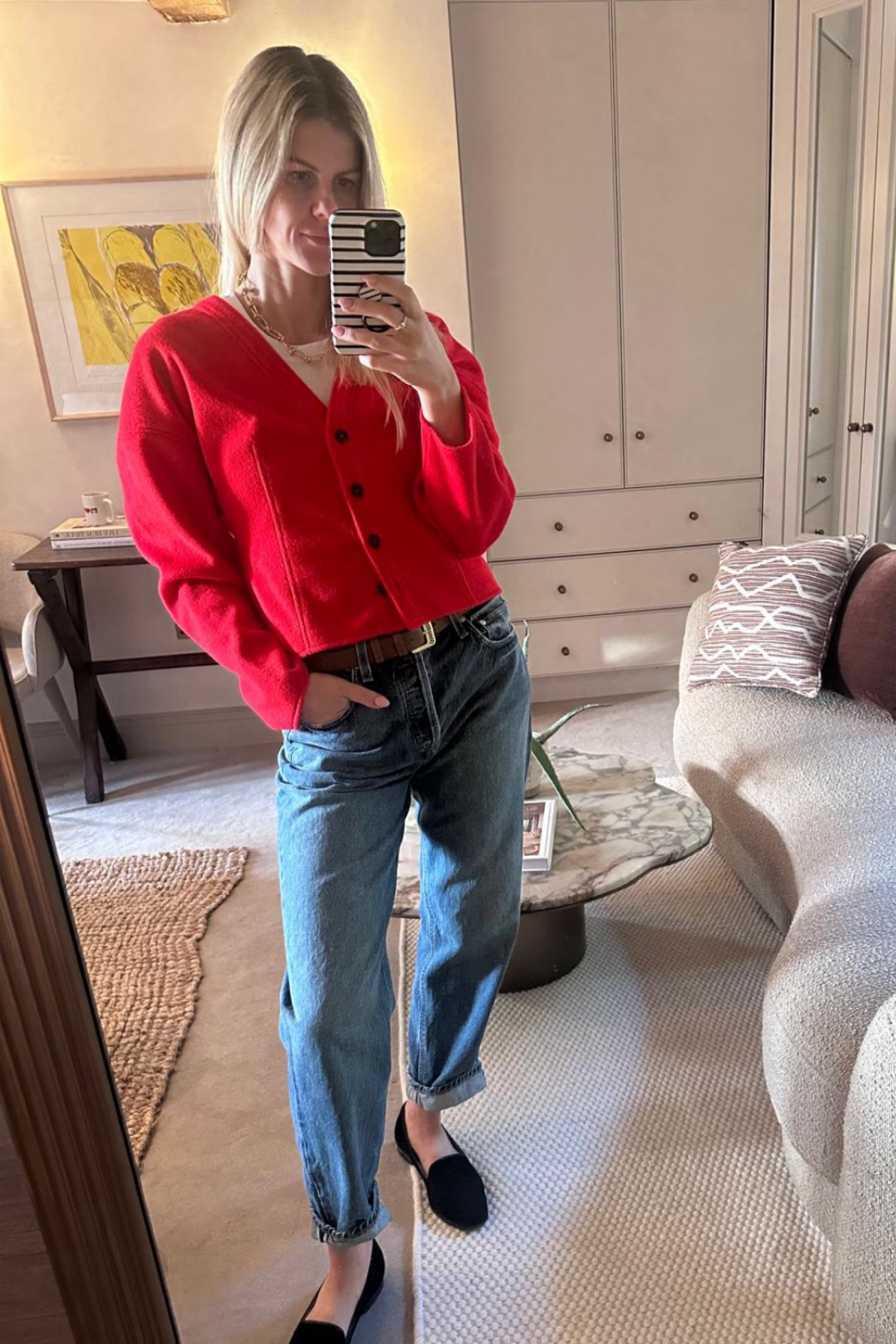 A plain white T under a red cardigan with a miu miu belt and a pair of blue straight leg jeans, and a pair of black flats  

#LTKworkwear #LTKstyletip #LTKireland