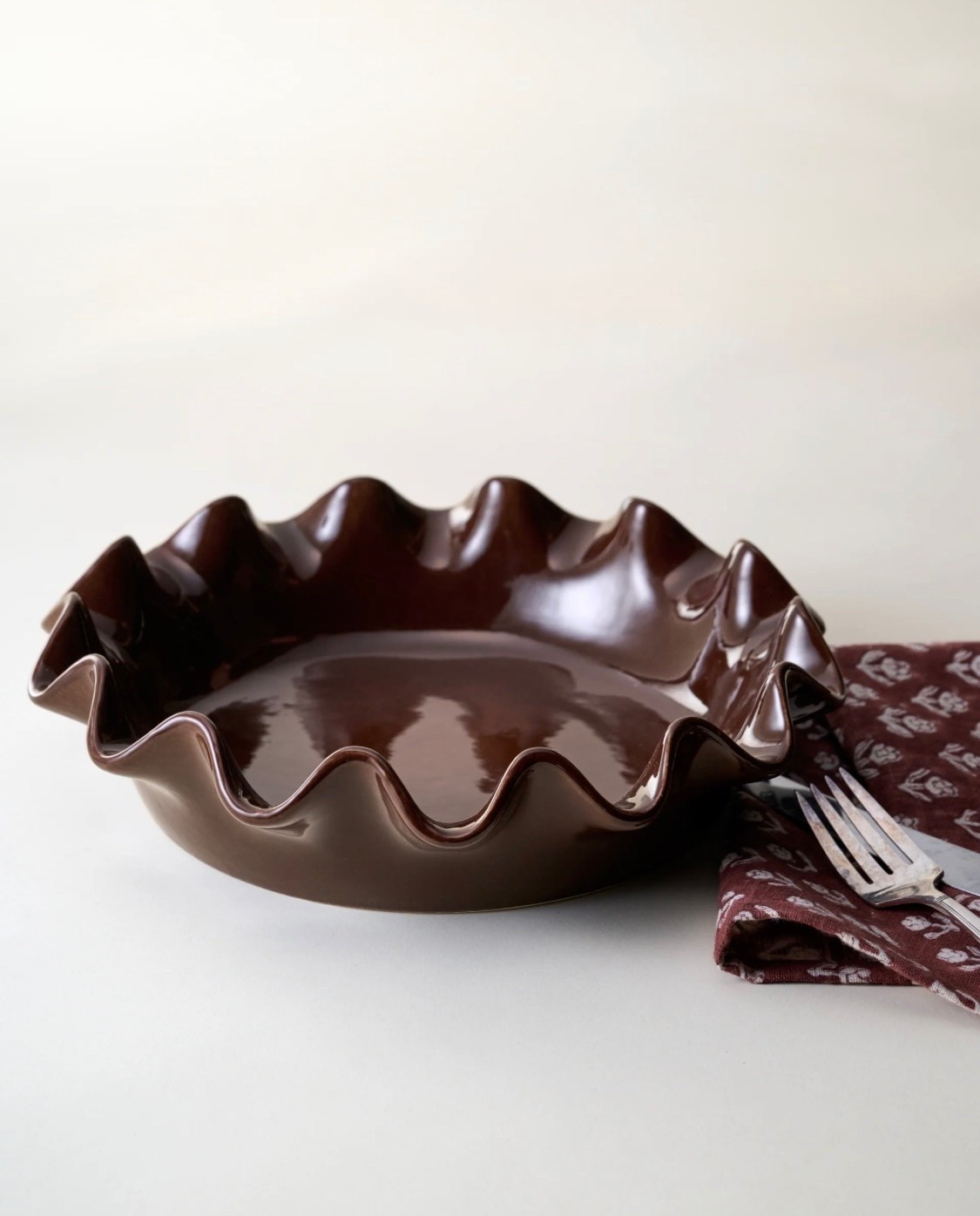 Designed to bring both beauty and intention to your kitchen, the Chocolate Scalloped Pie Dish is a rich update to our signature scalloped bakeware collection. Its deep chocolate brown glaze offers a warm, grounded tone that feels inviting and enduring, while the gently sculpted scalloped rim adds a subtle, heirloom-inspired detail that elevates its overall design