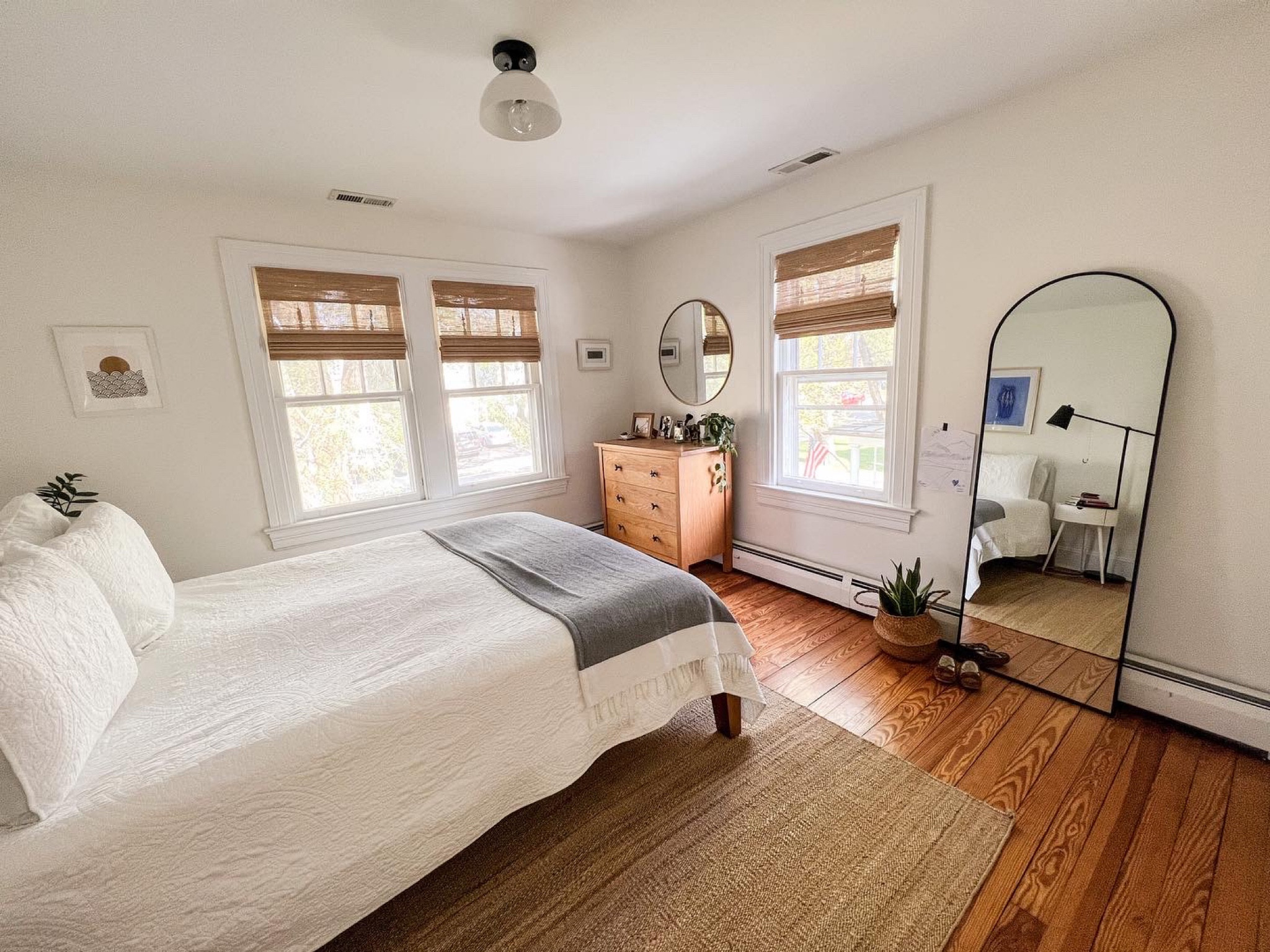 Bedroom with lots of natural elements balanced with black matte metal touches: jute area rug, bamboo Roman shades, plants, arched mirror, modern light fixture. Have linked similar items for vintage projects  

#LTKGiftGuide #LTKhome #LTKHoliday