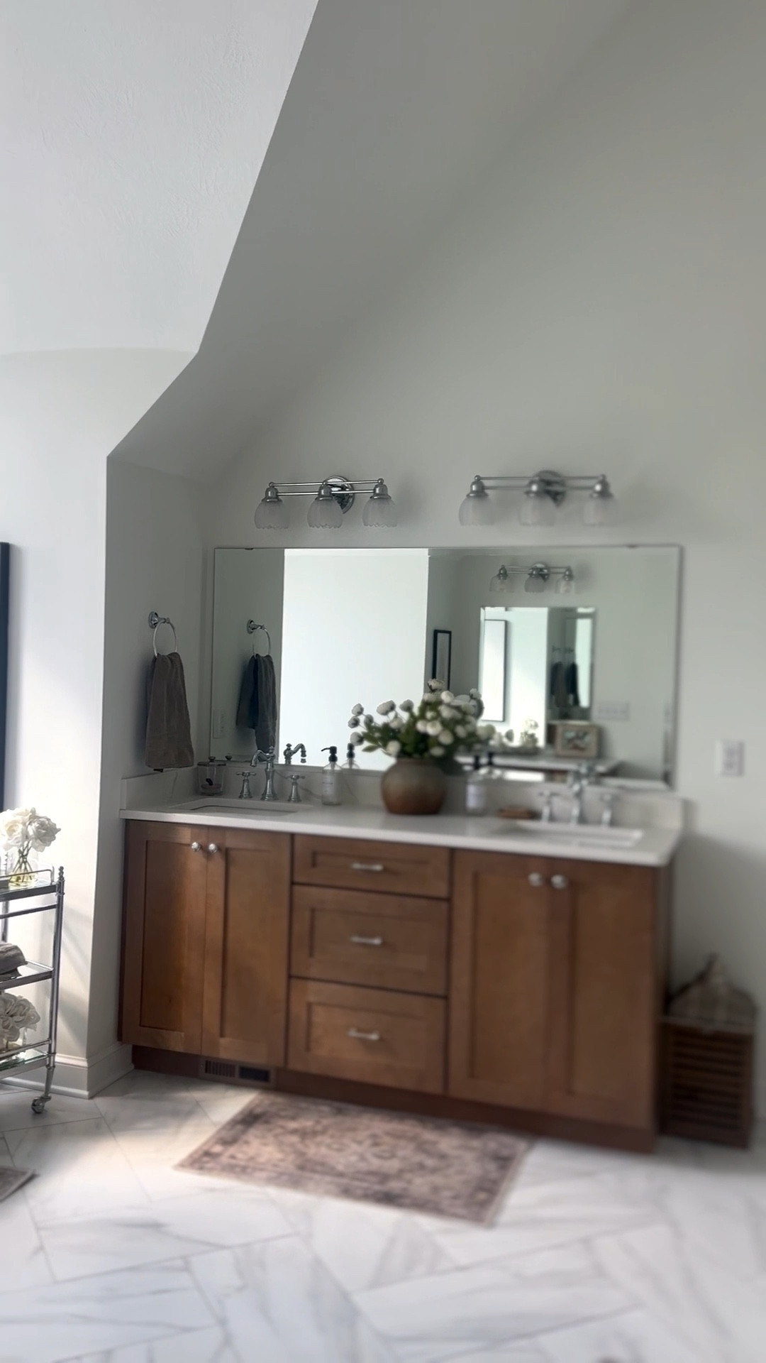 A view of our primary bathroom that feels so inviting & calming! Shop bathroom lighting, rugs, bath cart, faucet, and a similar wood vanity 🤎

#LTKHome