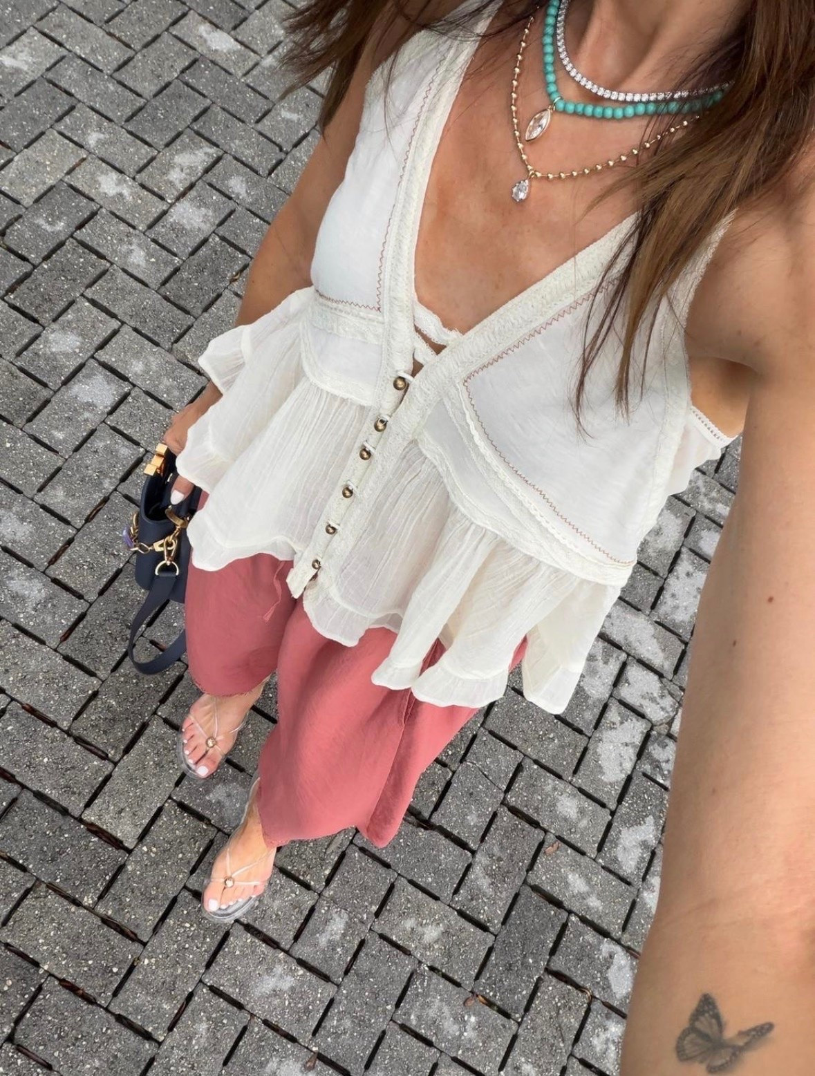 I wore this for a warm day when I wanted something loose but still styled. The airy white top has soft ruffles and subtle stitching that give it movement, while the dusty rose pants add color without overpowering the look. The relaxed fit stays comfortable through dinner, and the layered necklaces keep the neutral top from feeling plain.

flowy white top, dusty rose pants, relaxed summer outfit, lightweight blouse, wide leg pants, vacation dinner outfit, layered necklaces, warm weather style, casual chic outfit, neutral outfit with color, annabrstyle

#LTKOver40 #LTKootd #LTKSeasonal