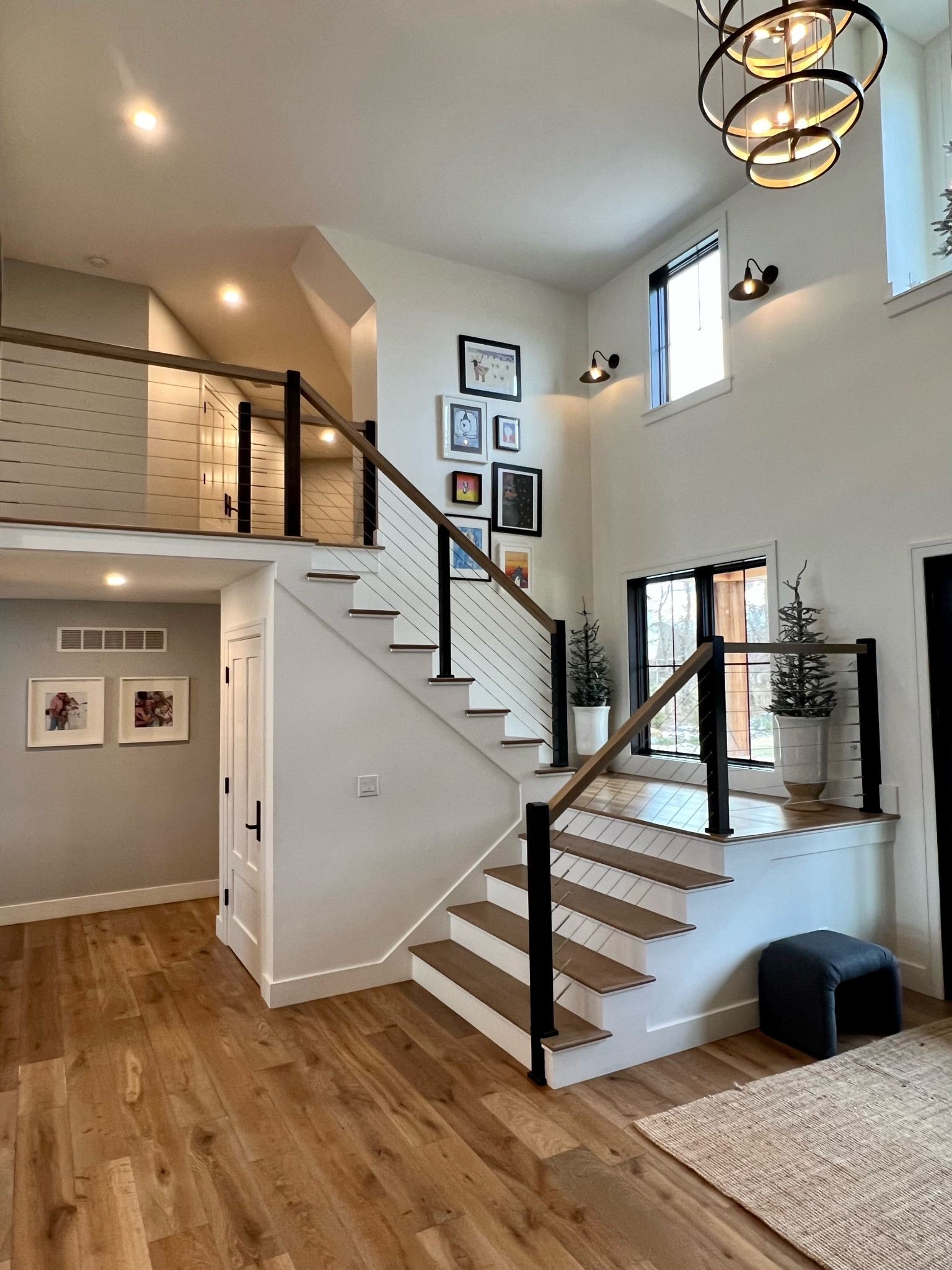 Modern entryway lighting. Rug. Ottoman. Stairwell decor  

#LTKstyletip #LTKhome #LTKsalealert