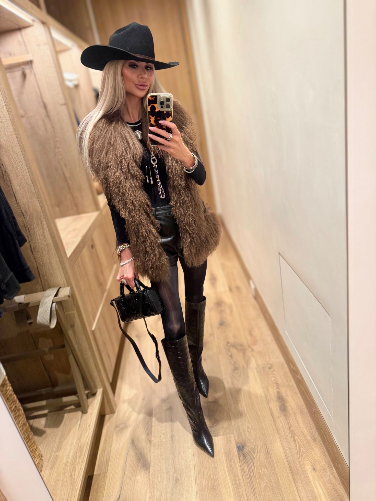 Aspen nights demand this head-turning combo—@Susanna Chow shearling vest over micro leather shorts @Revolve , sealed with a @Lack of Color cowboy hat & the most gorgeous Staud boots 🤠