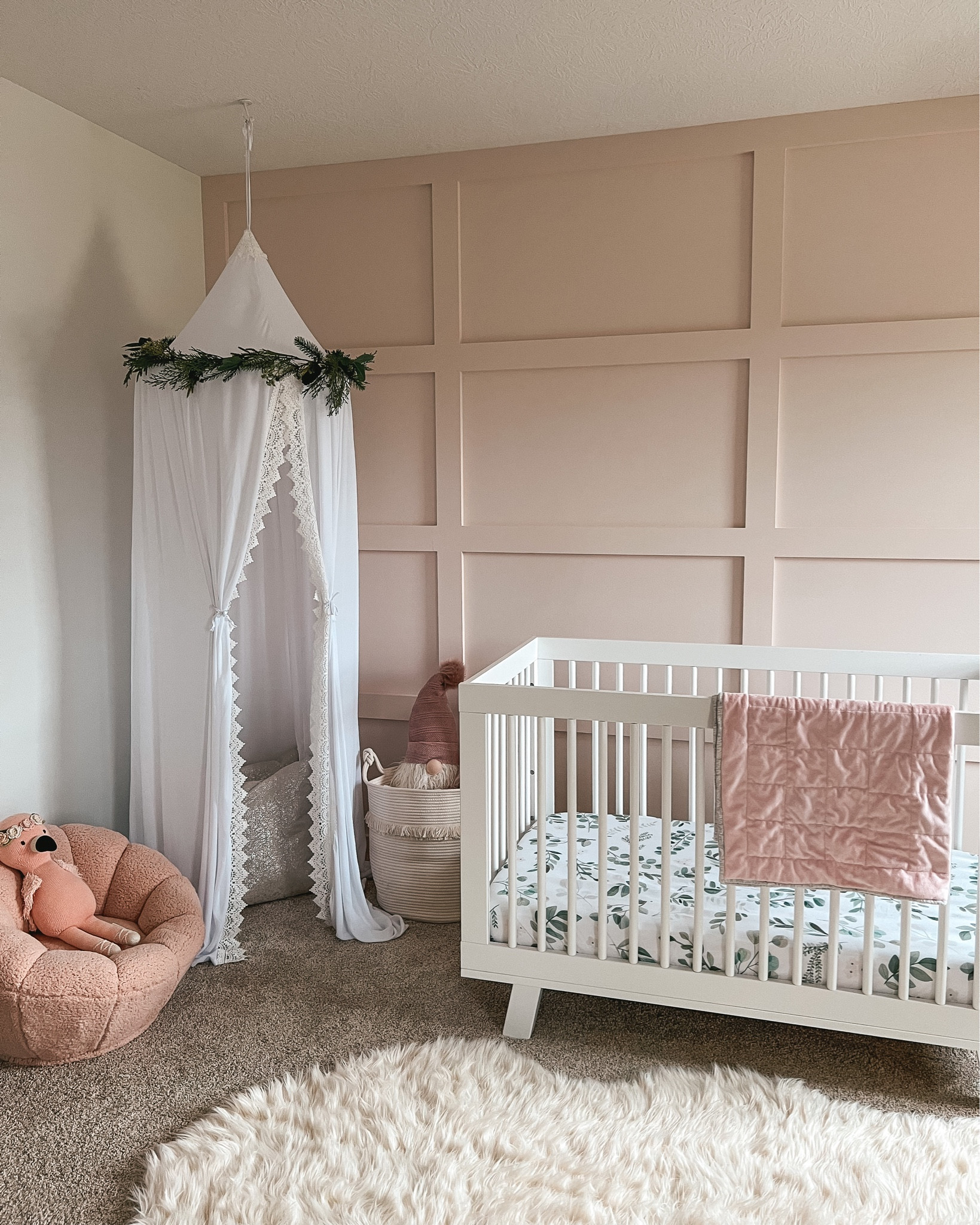 Baby girl nursery. Christmas decor. Toddler girl room. Accent wall. Toddler crib. Board and batten wall. Babyletto Hudson crib. Toddler room decor. Canopy. Playroom corner. Holiday home decor. 

#LTKhome #LTKHoliday #LTKbaby