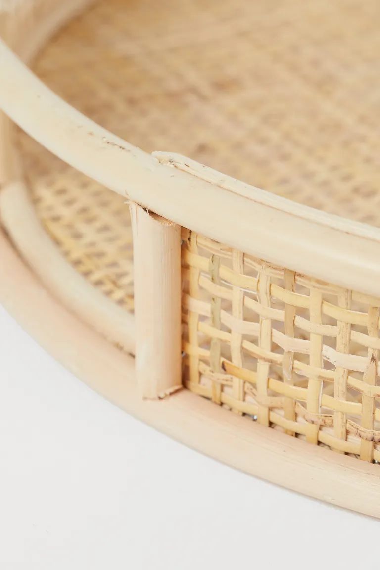 Round tray in braided rattan with handles at sides and a high rim. Height 2 1/4 in. Diameter 14 i... | H&M (US + CA)