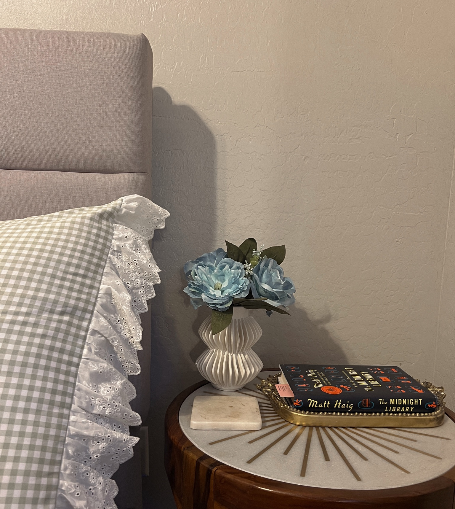 
✨Bedside Table Decor Styling✨
Featuring the Anthropologie Starburst Side Table with a wood base, marble top, and brass starburst detail. Styled with an Anthropologie Primrose Tray holding my current book, a marble coaster, and a CB2 vase filled with fun blue flowers for a pop of color. Complements my Dairy Boy green gingham pillow shams with lace fringe perfectly.