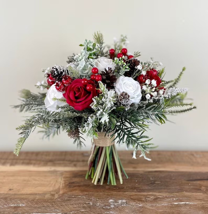 A picture-perfect bouquet for a winter or Christmas wedding ❄️❤️ This snow-kissed bridal bouquet from AdoredOccasions blends rich red berries, soft white silk roses, airy baby’s breath, natural pinecones, and lush evergreens for a timeless seasonal look. Finished with a twine-wrapped handle and bow, it adds the perfect rustic touch while still feeling elegant and romantic. Available in five sizes to suit your bridal party, this bouquet is designed to look beautiful long after your special day.

#LTKwedding #WinterWedding #ChristmasWedding #BridalBouquet #RusticBride #SilkFlowers #WeddingInspo #EtsyWedding

#LTKHome #LTKSeasonal #LTKHoliday
