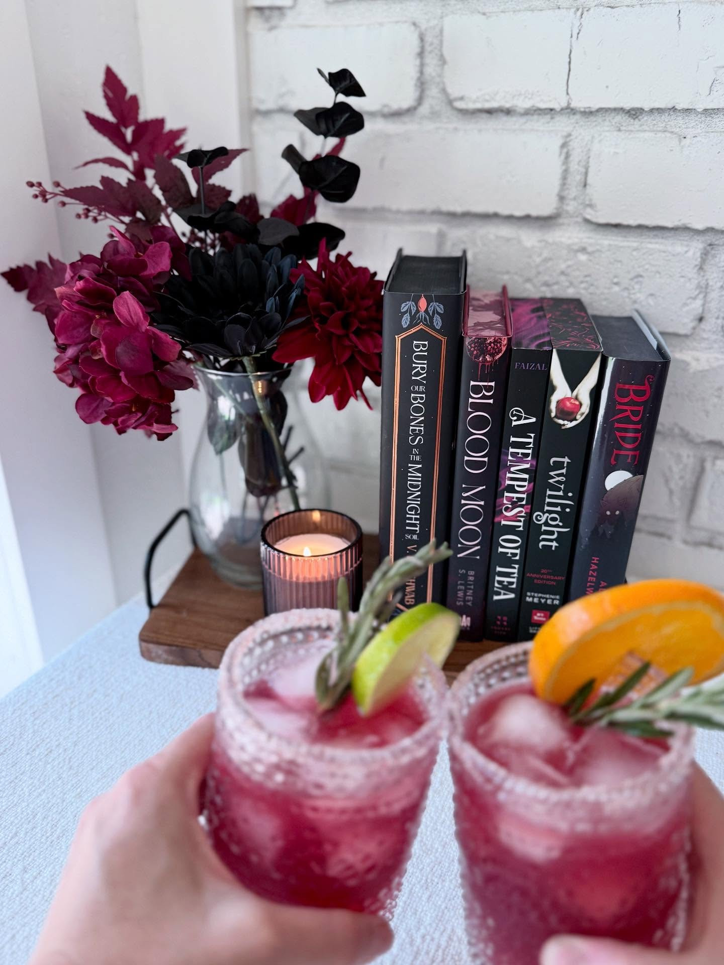 ✨Sips and Spines✨

Today I did a mix of vampire books I've read and enjoyed with some I'm looking forward to reading soon, and I paired them with a pomegranate margarita. To give you the vampire vibes without having to go to the blood bank.

✨Books I've Read✨

🤍 Twilight
🖤 Bride

✨Books I'm Excited to Read✨

🤍 Bury Our Bones in the Midnight Soil 
🖤 Blood Moon
🤍 A Tempest of Tea

✨Pomegranate Margarita✨

🩸1 ½ ounces 100% pomegranate juice 
🩸1 ½ ounces tequila
🩸1 ounce Triple Sec
🩸½ ounce lime juice 
🩸½ ounce simple syrup
🩸Salt for the rim (optional) - I used Himalayan Pink Salt

Rim glass with lime juice and then roll the edge in salt. Fill cup with ice  and set to the side. Put the rest of the ingredients into a shaker with ice and shake well. Strain drink into rimmed cup. You can garnish with lime slice, orange slice, pomegranate, and/or rosemary.

✨Pomegranate Marg Mocktail✨

🩸1 ½ ounces 100% pomegranate juice 
🩸1 ounce Orange juice 
🩸½ ounce lime juice 
🩸½ ounce simple syrup
🩸1-3 ounces Sparkling Lemonade 
🩸Salt for the rim (optional) - I used Himalayan Pink Salt

Put all ingredients into shaker with ice except for the sparkling lemonade. Shake well and pour into salt rimmed glass. Top with sparkling lemonade. I measured with my heart on this part. 😂 I think it was probably around 2 ounces give or take. Garnish the same as the margarita.

I originally planned to use a lemon lime soda, but realized we were out and I had some sparkling lemonade. So we tried that instead and it worked really well. I think you could easily get great results with lemon lime soda too. My youngest wasn't here today, but the 13 year old loved it. She said it's one of her favorites so far.

#LTKParties #LTKSeasonal #LTKHalloween