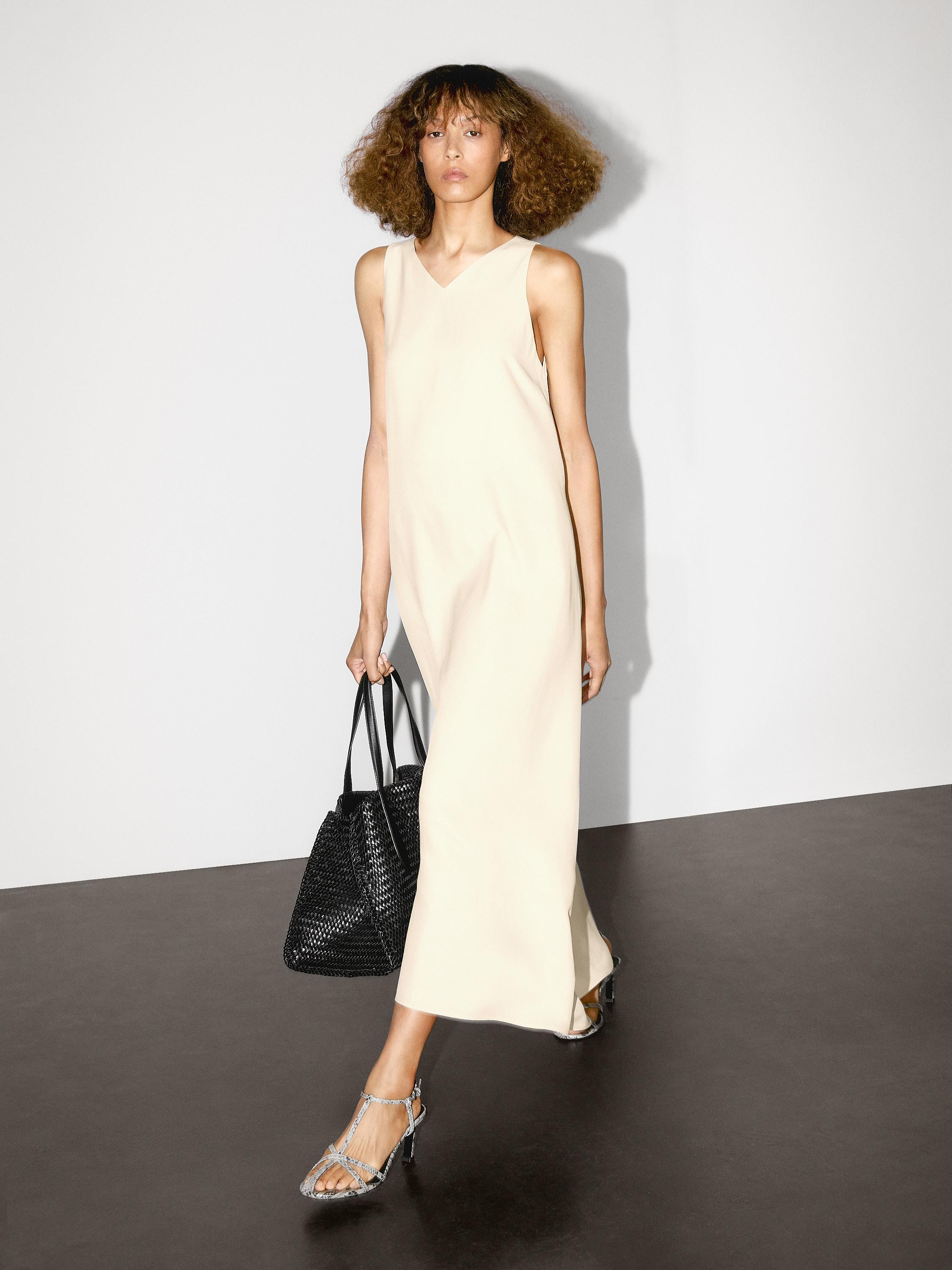 Langes weitschwingendes Kleid. V-Ausschnitt . Ärmellos. Seitliche Bänder an der Taille. | Massimo Dutti DE