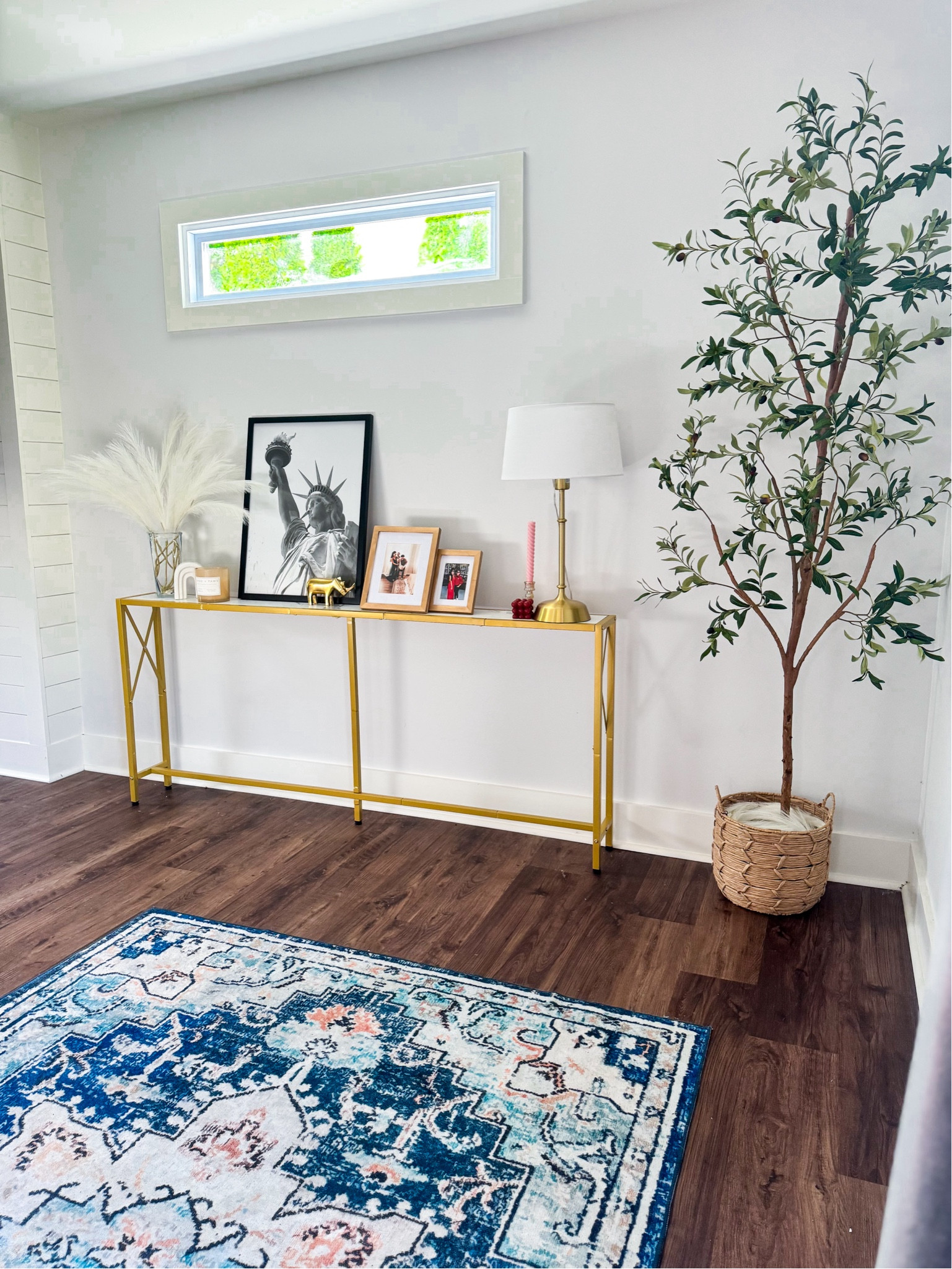 This awkward space in our living room has come a long way! This thin table is perfect for long, narrow spaces and exactly what we needed. It comes in other finishes but the white and gold was perfect for us. Our rug was on major sale and I got it under $30!! This tree is the tallest option and fills the space so well. Pampas was perfect for the end table to give a little height  Shop my exact and similar picks here. 

#LTKFallSale #LTKStyleTip #LTKHome
