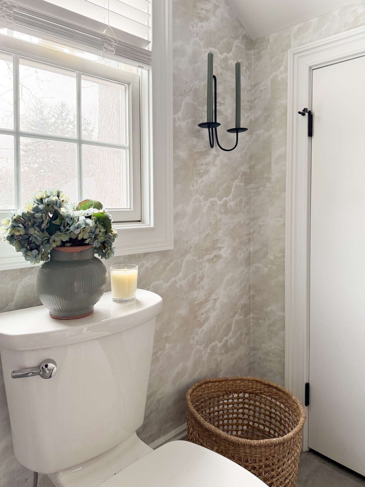 This soft, layered bathroom moment feels effortlessly elevated with the cloud like wallpaper and warm woven textures. The simple styling on the toilet tank, paired with the candle and hydrangeas, adds just the right touch of charm without overwhelming the space. Such a pretty way to make a small corner feel intentional and serene.

Attic bathroom, attic remodel, neutral bathroom decor, bathroom wallpaper ideas, small bathroom styling, woven basket decor, cozy bathroom accents, cottage style interiors, soft neutral home, bathroom vignette styling, classic home details, elevated everyday decor girlonthehudson

#LTKHome #LTKSeasonal #LTKdayinmylife