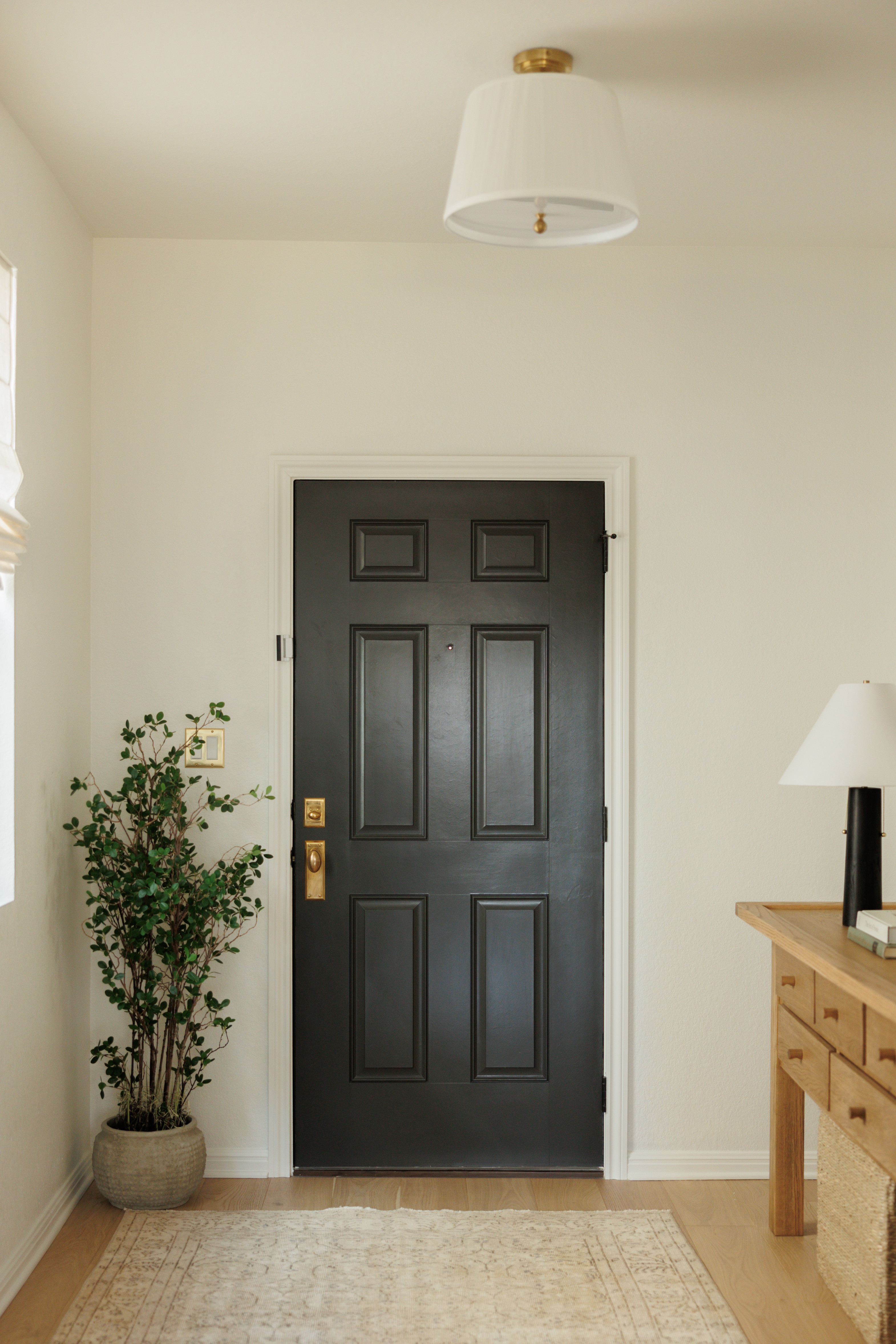 Entryway design at our Hill Country Haven Project! Wall + Trim Color: SW Greek Villa // Door color: SW Iron Ore. 

 #LTKHome #LTKStyleTip