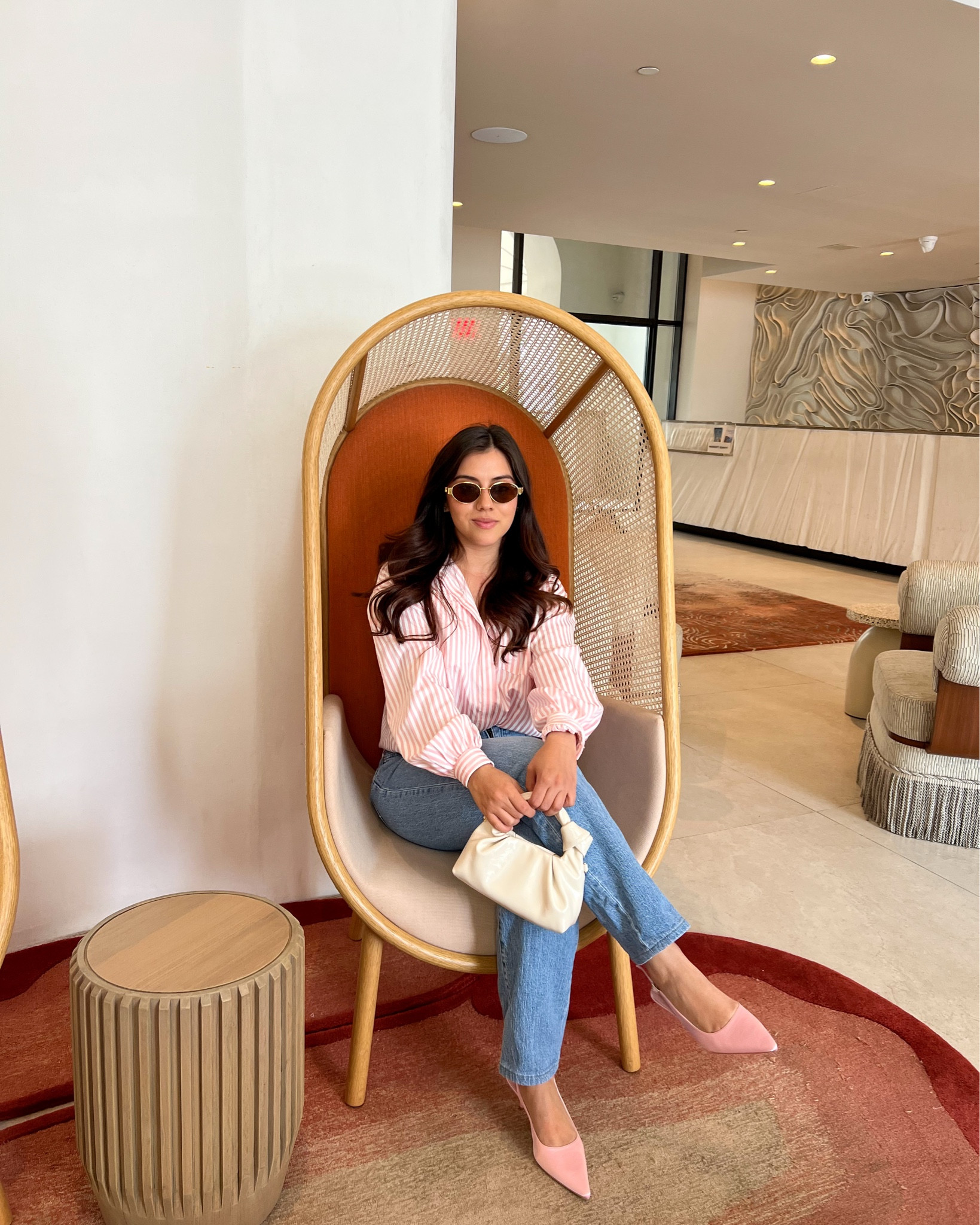 This spring-ready outfit features a pink and white striped button-down shirt paired effortlessly with classic high-waisted straight-leg jeans—perfect for a polished yet casual daytime look. Styled with blush pink pointed-toe heels and a soft ivory mini handbag, it strikes the ideal balance between feminine and chic. Shop this elevated everyday style on LTK for spring wardrobe staples and neutral accessories that pop.

#LTKSeasonal #LTKStyleTip