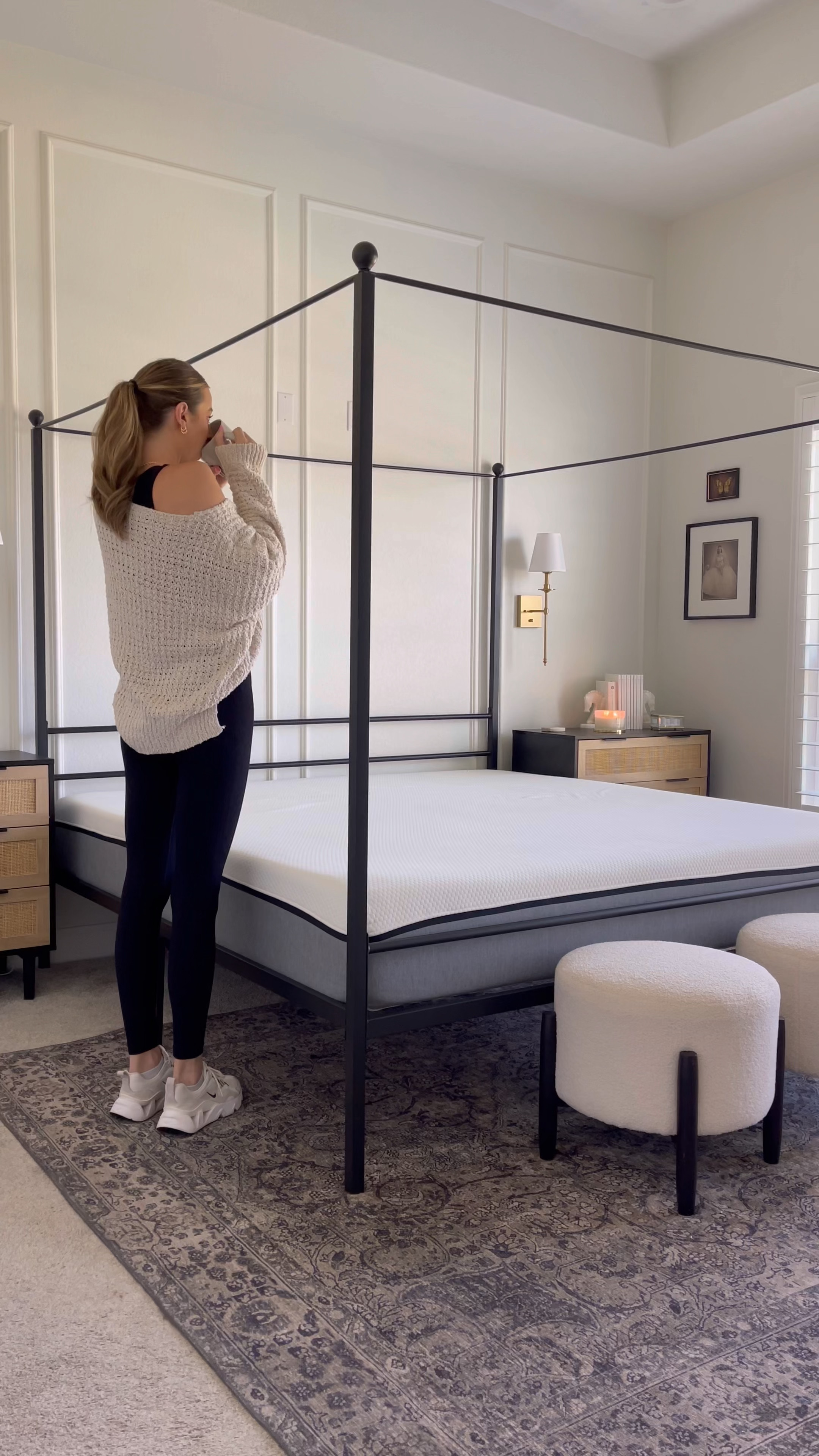 Bedroom details, black metal canopy bed, black nightstands, gold sconces