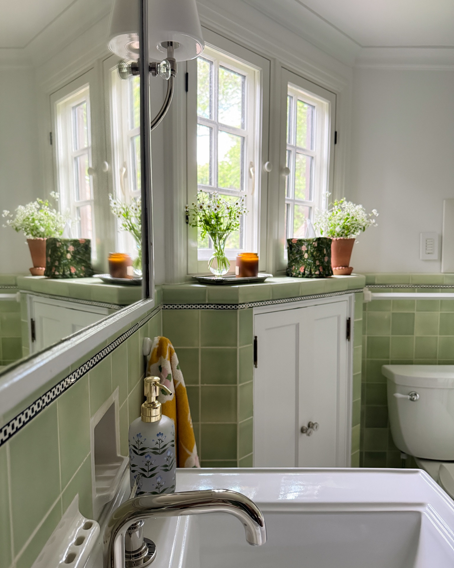 Green bathroom makeover. The polished nickel faucet + sconces and the pretty accessories paired so well with the almost 100 year old green tiles. Polished nickel fixtures will instantly elevate any space!