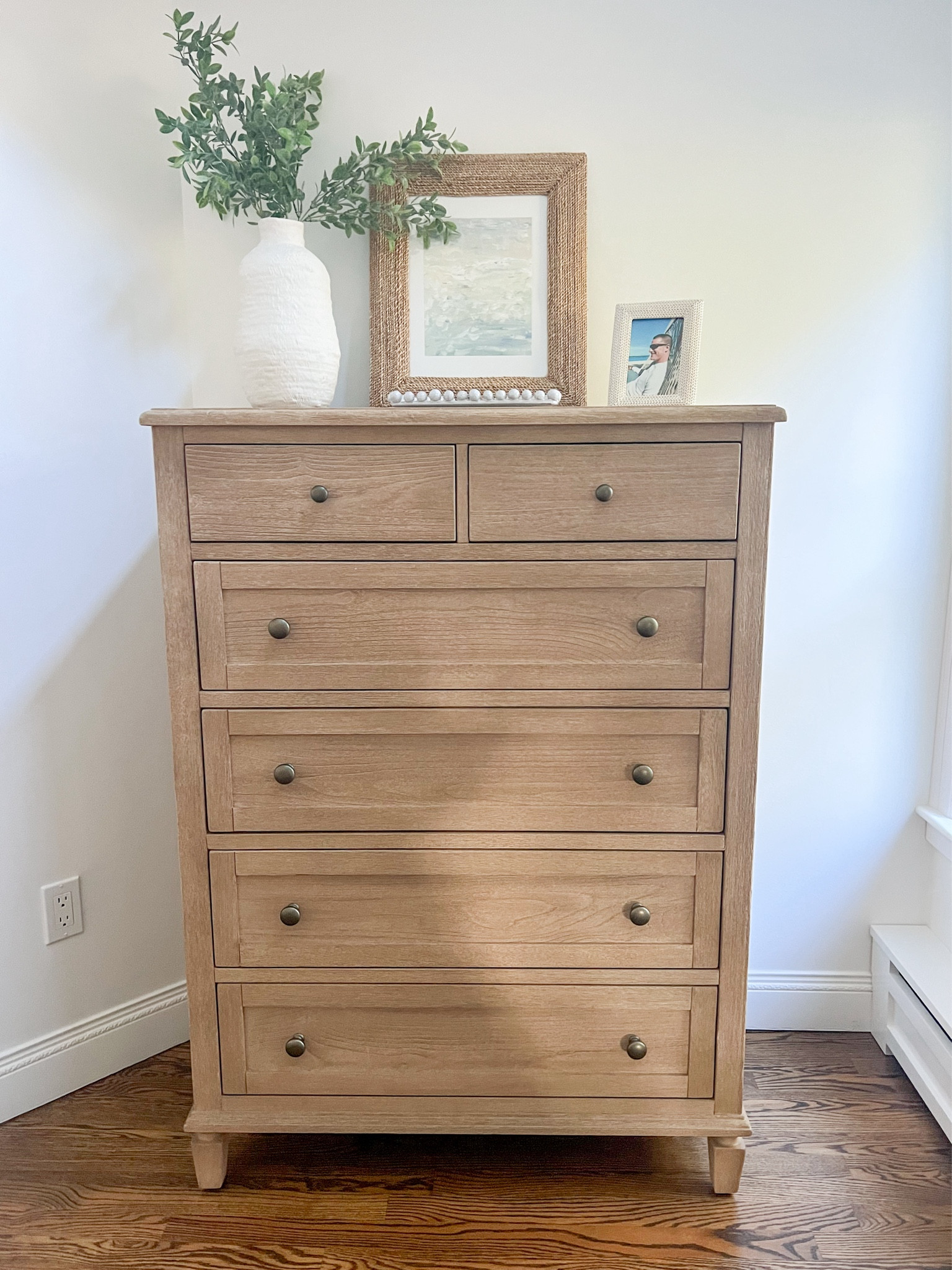 I love how the this wood dresser adds so much warmth to our white bedroom!
- 
coastal home decor, pottery barn dressers, coastal bedroom furniture, sausalito dresser, coastal dressers, wood dressers, primary bedroom ideas, primary bedroom furniture, tall dressers, 6-drawer dressers, dresser styling, white vases, tall vases, coastal artwork, woven frames, dresser decor, picture frames, jewelry tray, trinket dish, abstract artwork, lindsay letters art, coastal style, beach house furniture, beach house decor, coastal decor

#LTKStyleTip #LTKHome