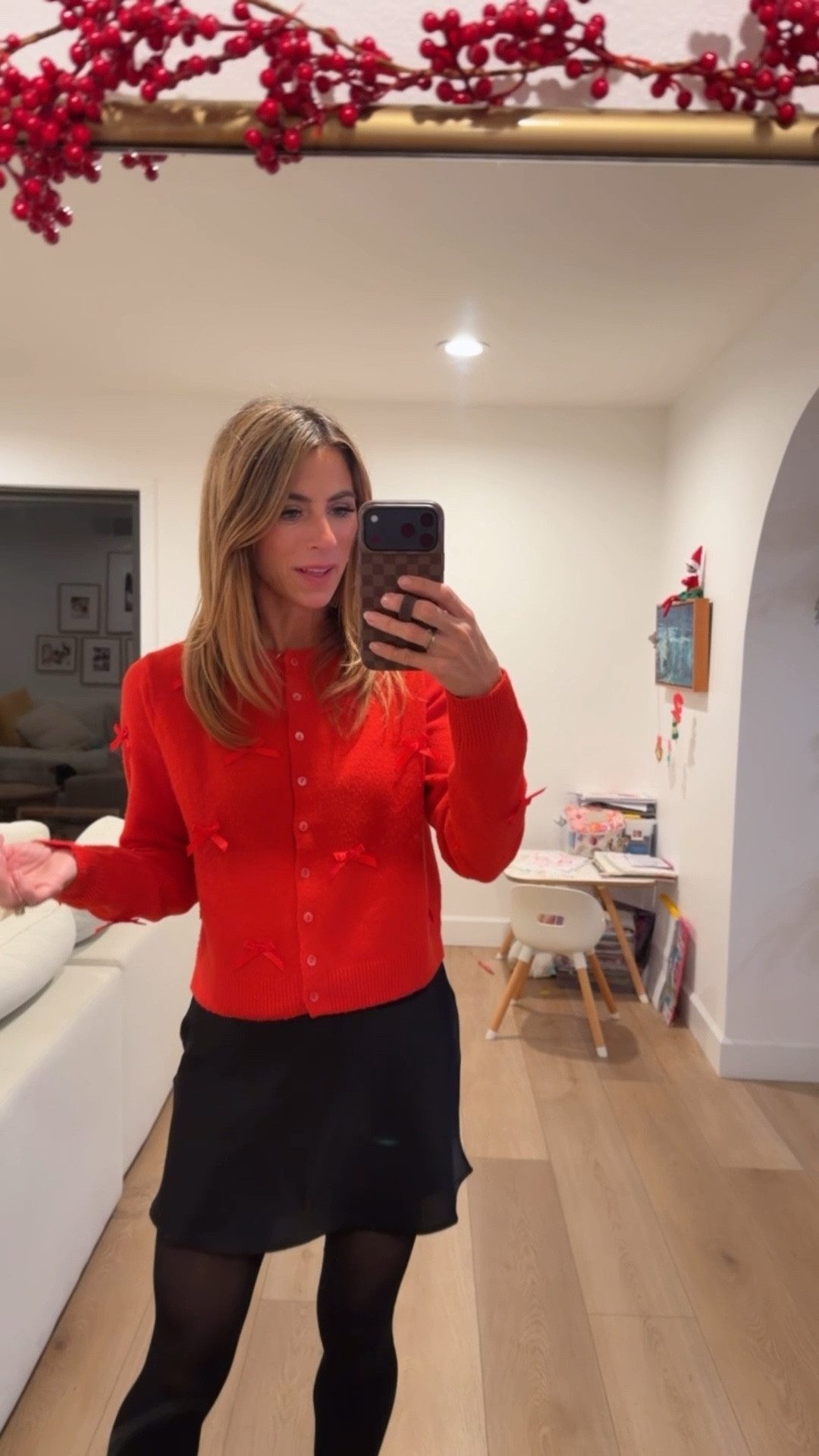 A festive holiday outfit 🎅 the sweater is super affordable, & I’ve already gotten a lot of use out of it! red sweater with bows. Black boots. Satin skirt. Black skirt. Target sweater. Holiday party outfit. Christmas outfit. Christmas sweater 