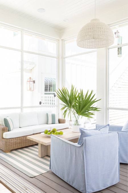 A look at our outdoor living room in our screened in porch! We absolutely love this outdoor sofa, upholstered swivel chairs, wood coffee table, rope chandelier, striped outdoor rug and coastal accents! See our full new home tour here: https://lifeonvirginiastreet.com/a-peek-at-our-new-florida-home/.
.
#ltkhome #ltkseasonal #ltkstyletip #ltkfindsunder50 #ltkfindsunder100 #ltksalealert #ltkfamily outdoor living room, pool furniture, patio furniture, blue and white decor, coastal grandmillennial style

#LTKSeasonal #LTKsalealert #LTKhome