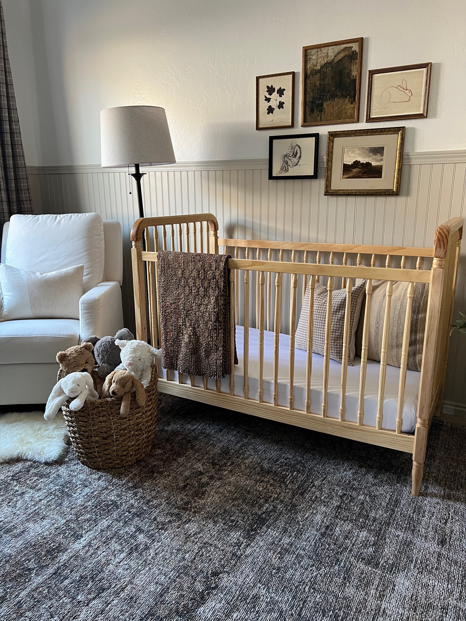 Neutral nursery styling 

Neutral spindle crib light natural wood upholstered glider white fabric check plaid throw pillow cover dark beige kilim stripe tan ivory pillow cover brown kantha quilt vintage framed art landscape vintage city brown rug Jellycat stuffed bunny doggy plaid drapery curtains vintage aged brass rocking horse arched mirror vintage childs chair iron floor lamp small faux tree 

#LTKhome #LTKstyletip #LTKFind