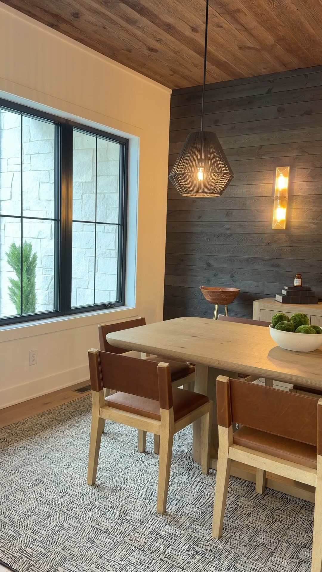 Designed for the way people actually live and gather.

Warm wood tones, soft lighting, and layered textures create a space that feels inviting without trying too hard. The darker wall grounds the room, while the mix of materials keeps it balanced and interesting.

A dining room that works for everyday moments but still feels special when it needs to.

#LTKHome
