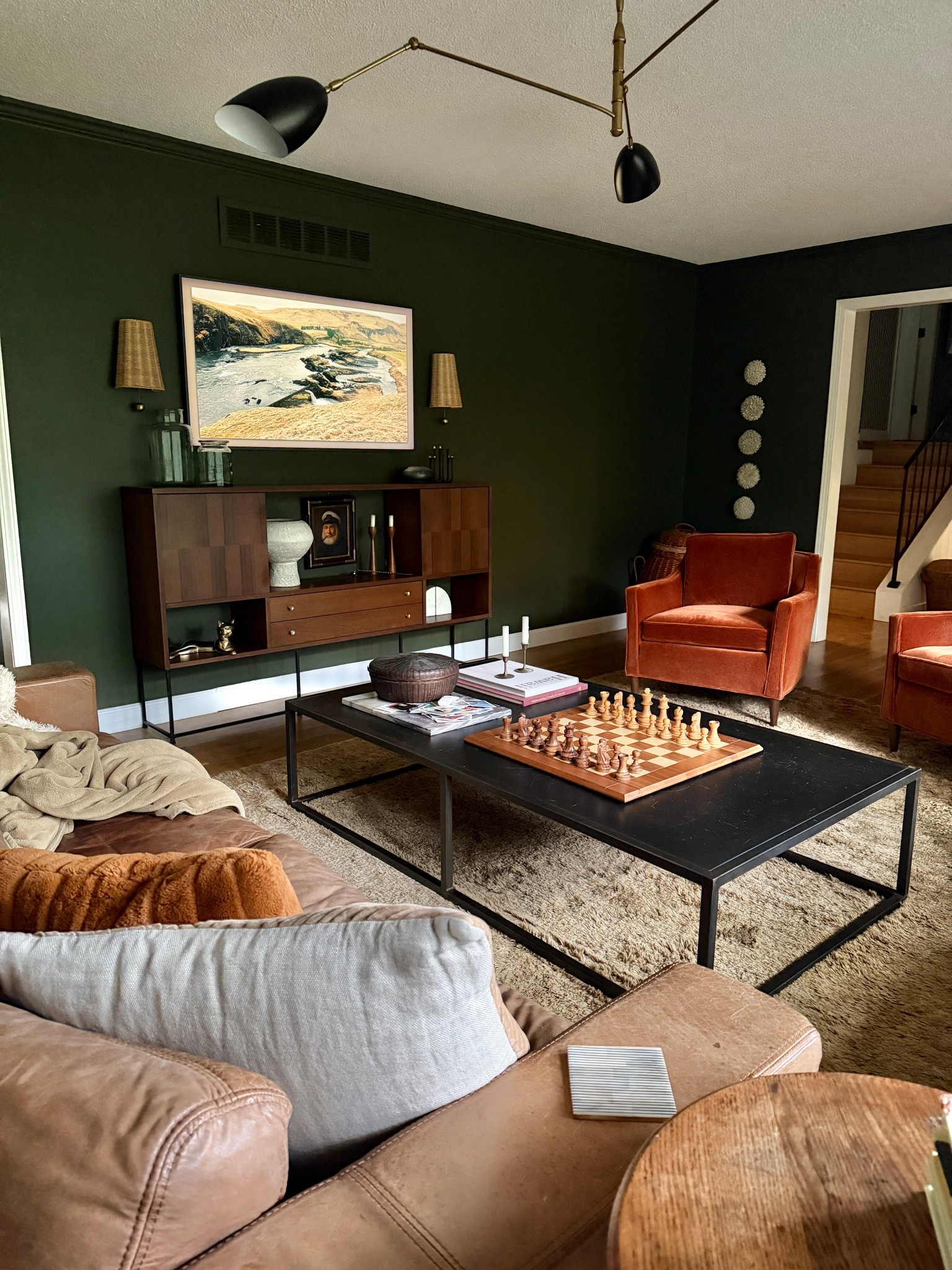 Love the added texture around the tv  that the sconces add. Moody living room vibes for sure. 