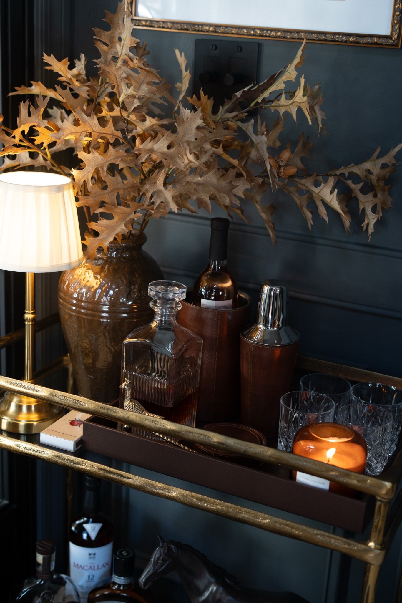 Guys, I just redid my bar cart with the modern heritage aesthetic and I'm absolutely LOVING it! A brass bar cart, leather wine bucket and cocktail shaker, a crystal decanter, cut crystal glasses, and a cordless brass lamp with a pleated shade. Add faux oak leaf stems with acorns and a glowing candle, and it's pure cozy fall bar cart styling. 🍂🥃

#barcart #barcartstyling #falldecor #modernheritage #falldecorideas #homebar #cozyhome
