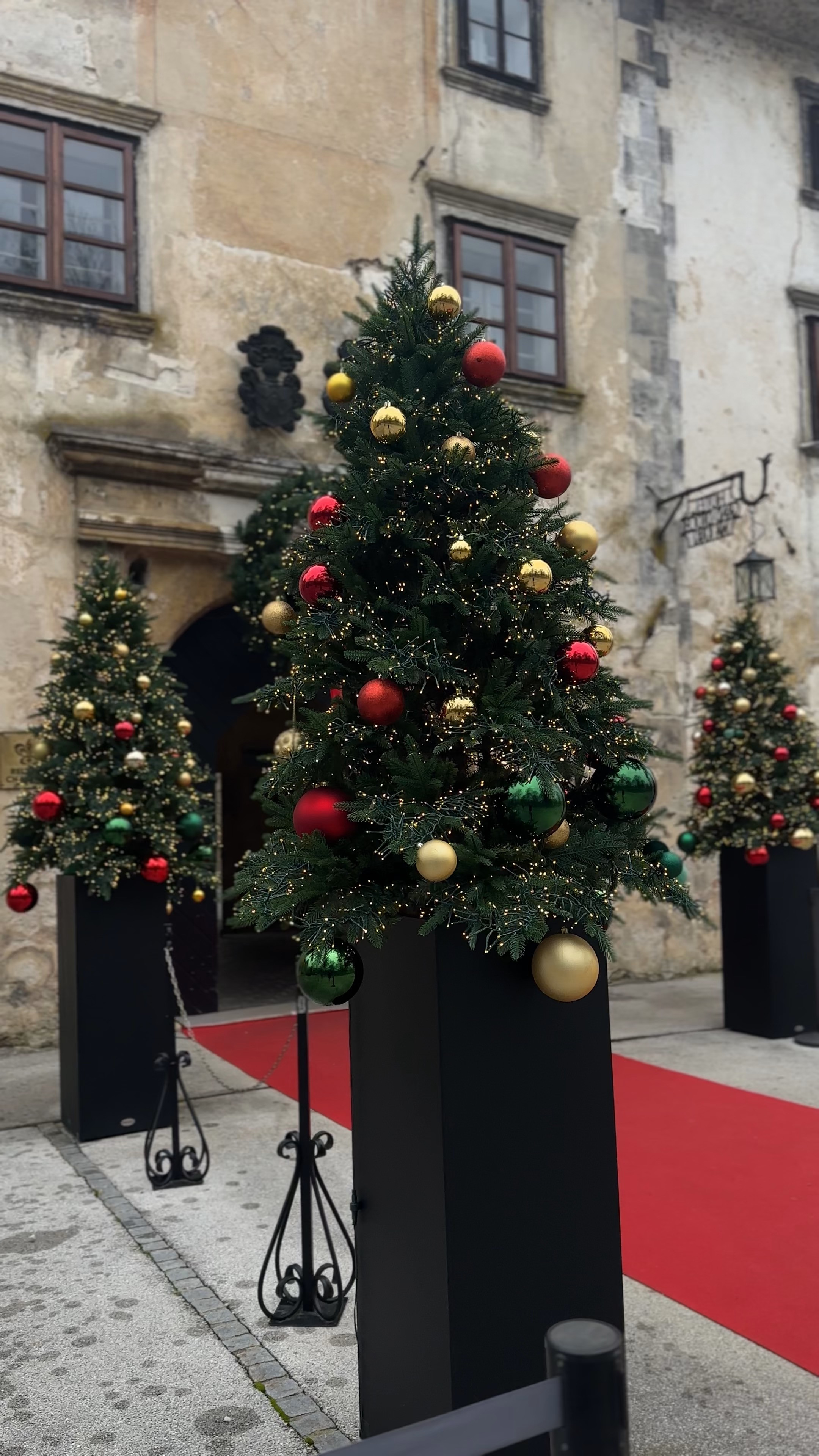 Christmas tree decorating ideas, outdoor Christmas decor, European Christmas market, red gold green ornaments, festive holiday display, traditional Christmas colors, holiday entrance decor, Christmas tree inspiration, winter festive atmosphere, classic Christmas aesthetic, holiday decorating ideas, Christmas ornament styling, European holiday traditions, red carpet Christmas, elegant outdoor decor, festive winter scene, Christmas market vibes, holiday celebration, traditional tree decorating, Christmas photography 

 #LTKHoliday #LTKHome