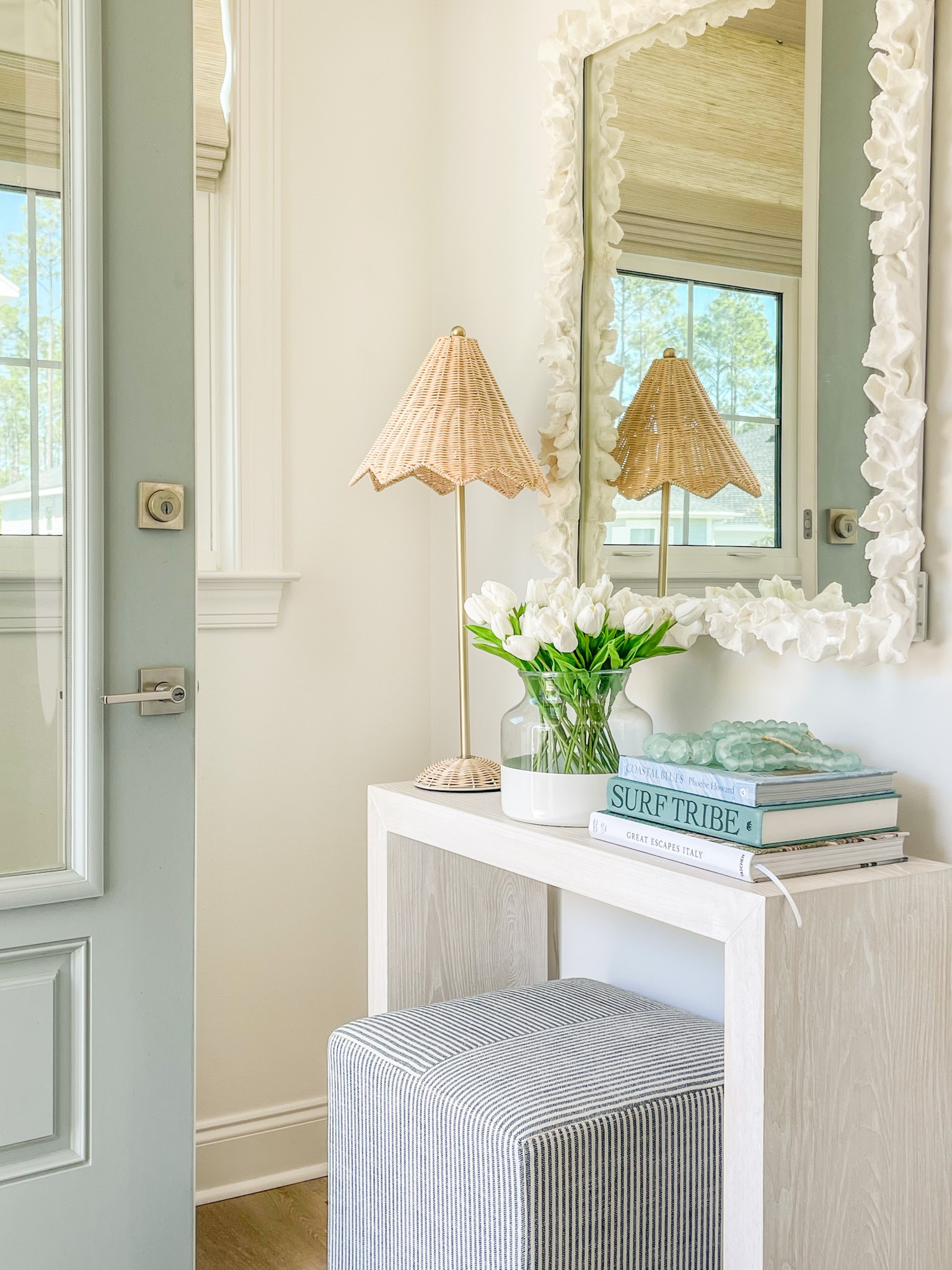 Spring and summer decorating in our entryway! This slim console table is perfect for this right space. I decorated for spring and summer with this scalloped wicker lamp, my favorite faux tulips, a colorblock vase, coastal coffee table books, recycled glass beads, striped ottoman cube and a white coral mirror! 

. entryway decor, spring decorating ideas

#ltkhome #ltkseasonal #ltkunder50 #ltkunder100 #ltkstyletip #ltksalealert   

#LTKunder50 #LTKhome #LTKSeasonal #LTKsalealert