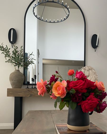 Get the look. Transitional living room. Neutral home decor. Wagon wheel chandelier. Arched floor mirror. Huge arch mirror. Black vase. Black candlesticks. Black candle holder. Candle sconce. Horse bust. 