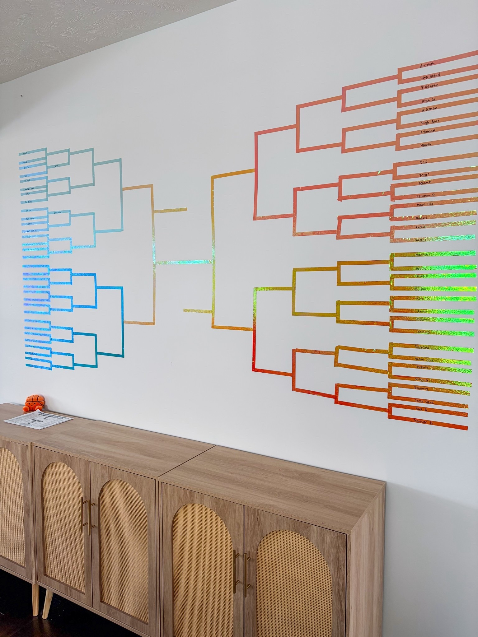 March Madness, but make it cute!! 🏀😉🏆 Project a bracket on to your wall to easily create this with tape. It took me a couple of hours with help from my youngest (as you can see on the bottom R corner!) 

#LTKKids #LTKSeasonal