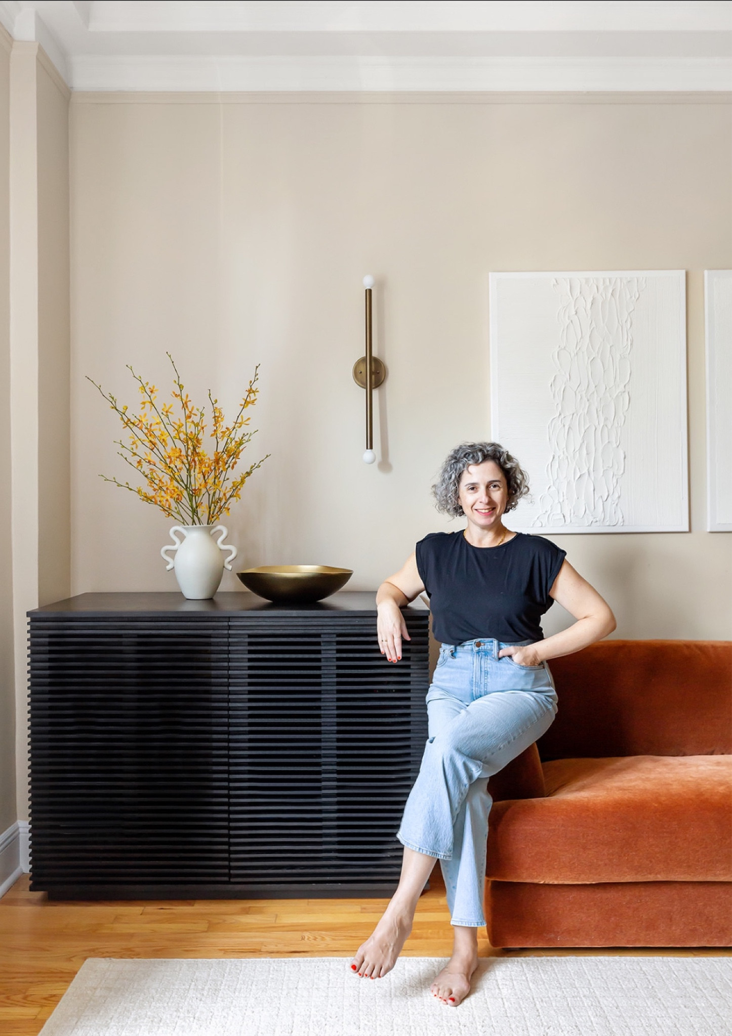 Welcome to one of our most loved living room design projects! The ebonized cabinet has SO much storage and makes a real statement and the burn orange sofa is elegant and comfy. It all ties together beautifully with our Etsy artwork and brass sconces. And of course me:)

#LTKhome #LTKMostLoved #LTKstyletip