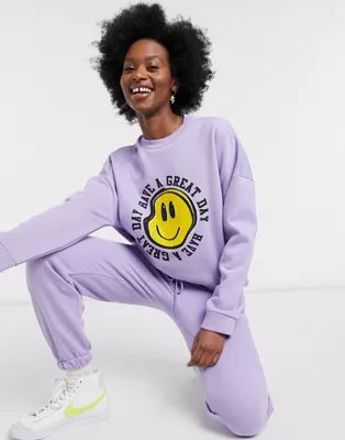 ASOS DESIGN tracksuit oversized sweat / oversized jogger with happy face graphic in lilac | ASOS (Global)