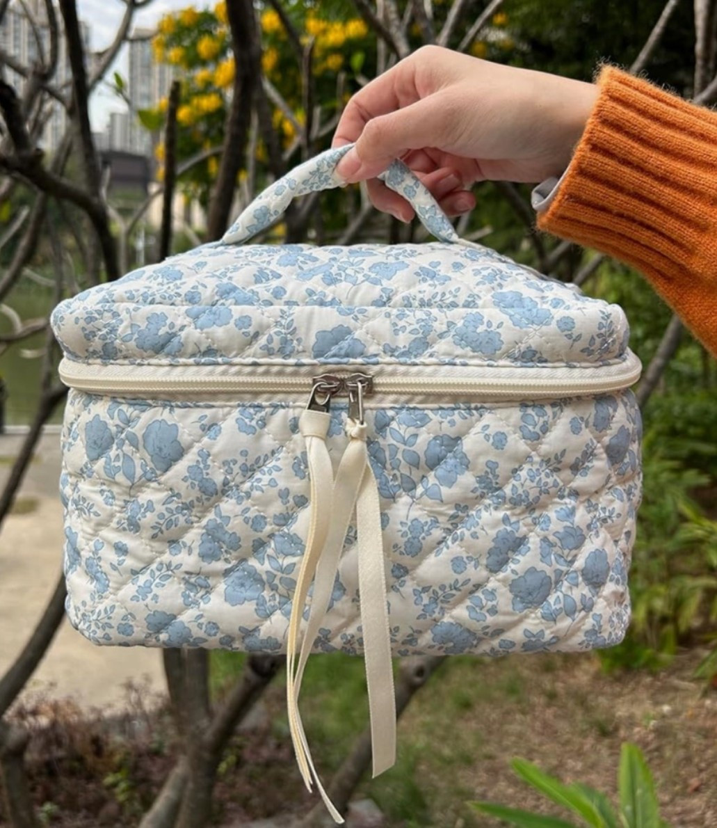 Quilted floral makeup bag with that pretty travel toiletry feel that makes packing your beauty essentials so much easier. 🌿 Perfect for vacations, weekend trips, gym bags, carry ons, bathroom organization, skincare, makeup, brushes, hair accessories, or everyday touch ups when you want everything in one cute place. The large size, soft quilted texture, and little blue flower print make it feel feminine, practical, and easy to toss in a suitcase. 

Grab this makeup bag if your travel routine needs a prettier way to stay organized. 🌼

#LTKTravel #LTKOver40 #LTKBeauty