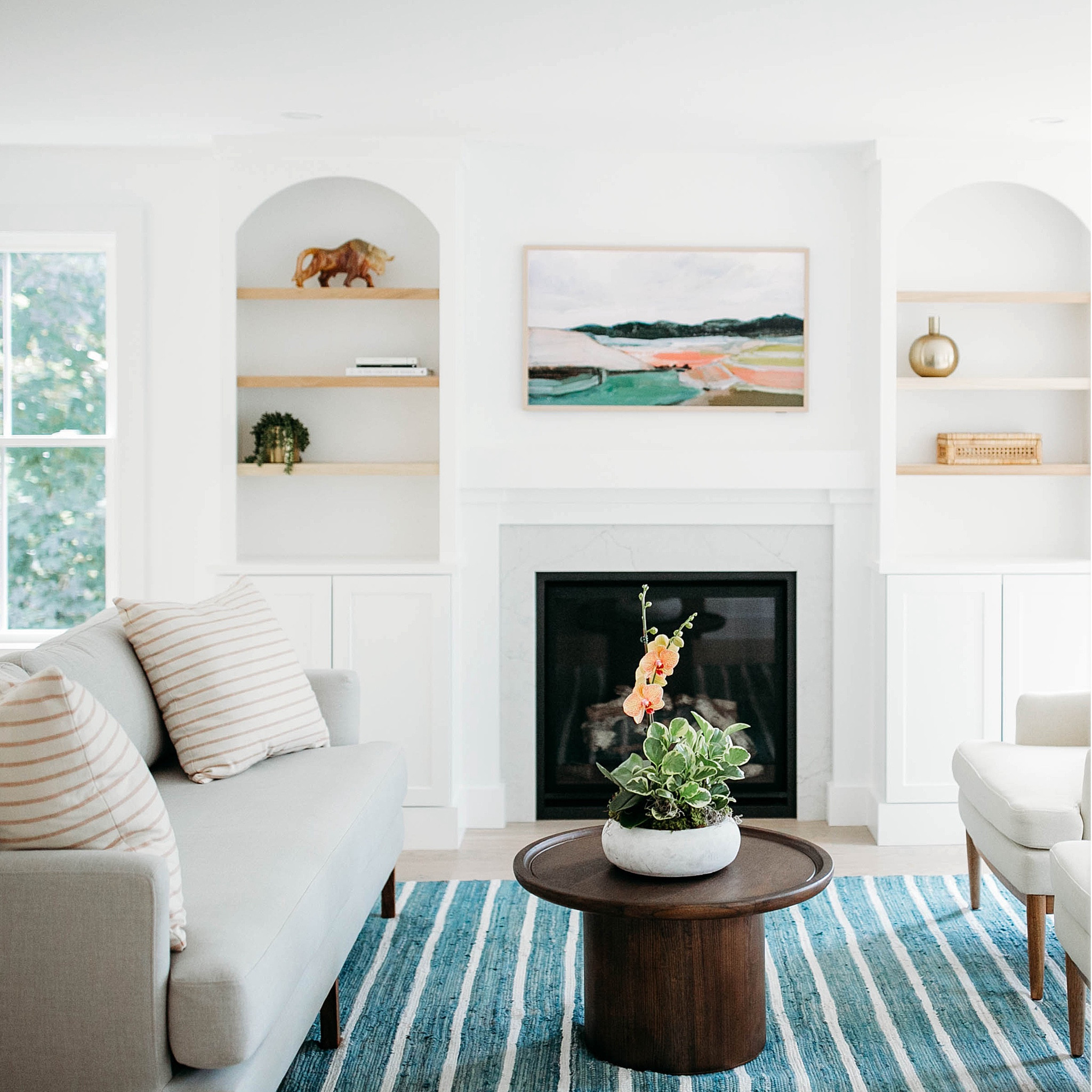 our goal with this #dwelloctoberstudio design project was to update a '90s builder grade home with lighter, brighter finishes that had a classic, yet modern feel. the living room was a long, rectangular space that had historically proved challenging to find a cohesive furniture layout. to remedy this, we added custom built-in bookcases and a more substantial mantel to make the fireplace the focal point of the room and create character in the home that looked as if it had always existed. new windows, light oak hardwood floors, and fresh white paint transformed the room into an inviting place to relax and unwind. #dwelloctober

#LTKhome