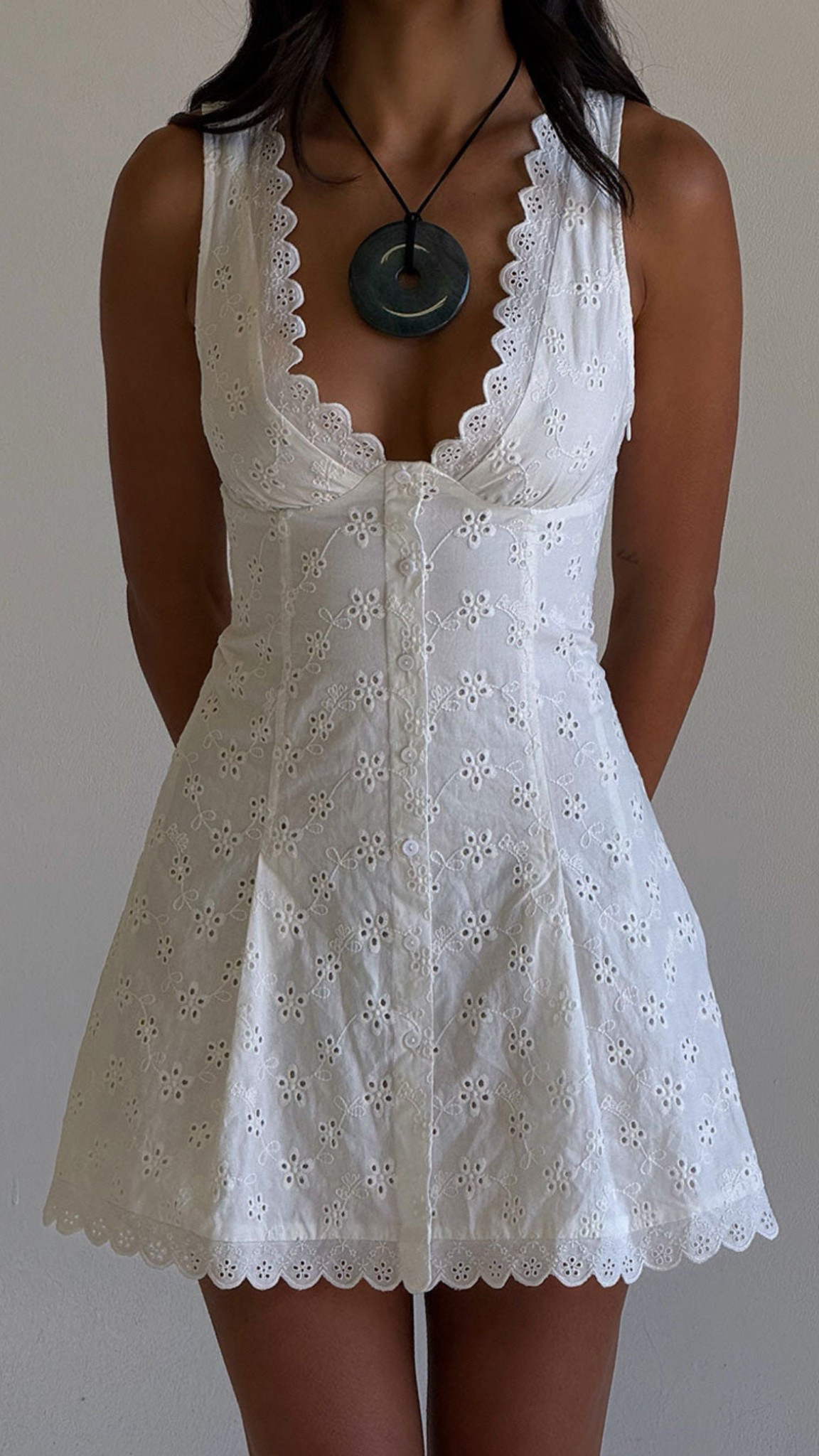In collab with Bella Hadid, fall in love with effortless summer style in this romantic white eyelet mini dress from Frankies Bikinis 🤍 Featuring a flattering button-down front, scalloped hem, and plunging neckline, this lightweight cotton dress is perfect for beach days, brunch dates, or your next vacation. Feminine, flirty, and breathable – it’s the ultimate summer staple for 2025