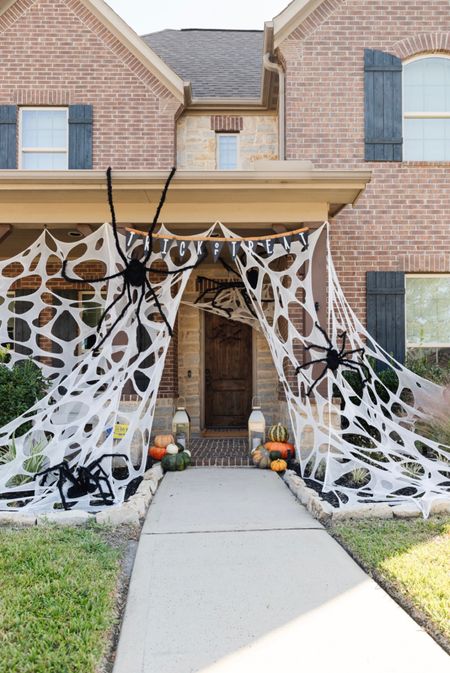 DIY outdoor spider webs for Halloween.  Cut holes into the netting linked below to look like large spider webs for your outdoor Halloween decorations 🕸️