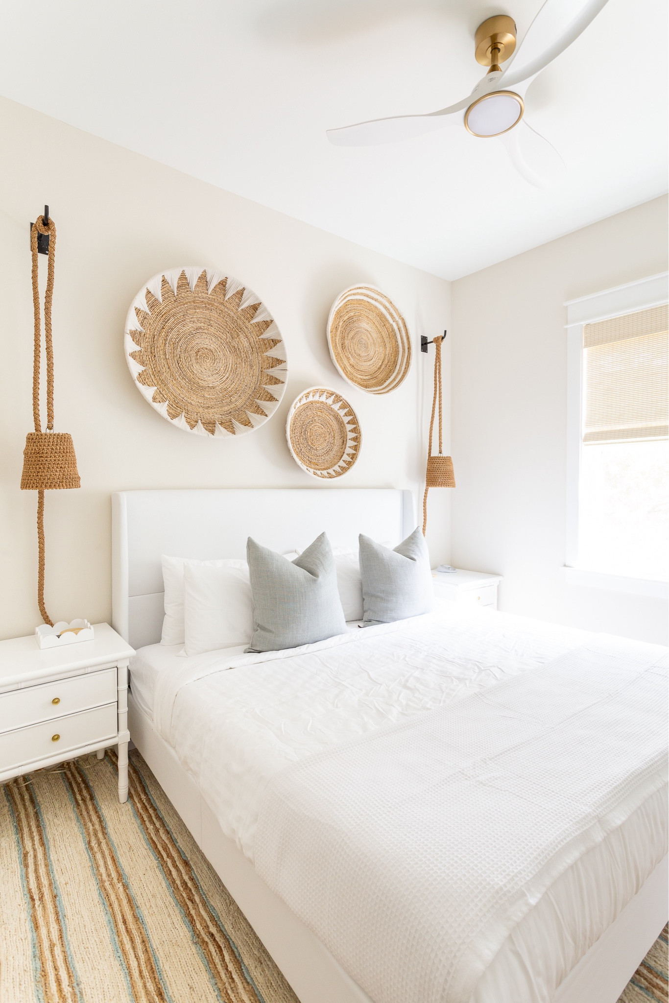 A look at of one of the Hola Beaches Casita king bedrooms! I decorated with this white upholstered bed, white bamboo nightstands, light blue linen pillow, basket art set, rope pendant lights, and a striped jute rug! See more pics and the full home tour here: https://lifeonvirginiastreet.com/hola-beaches-casita-30a-tour/.
.
#ltkhome #ltksalealert #ltkstyletip #ltkfindsunder100 #ltkfindsunder50 #ltkseasonal beach house decor, beach house bedroom, 30A decor 

#LTKSeasonal #LTKHome #LTKSaleAlert