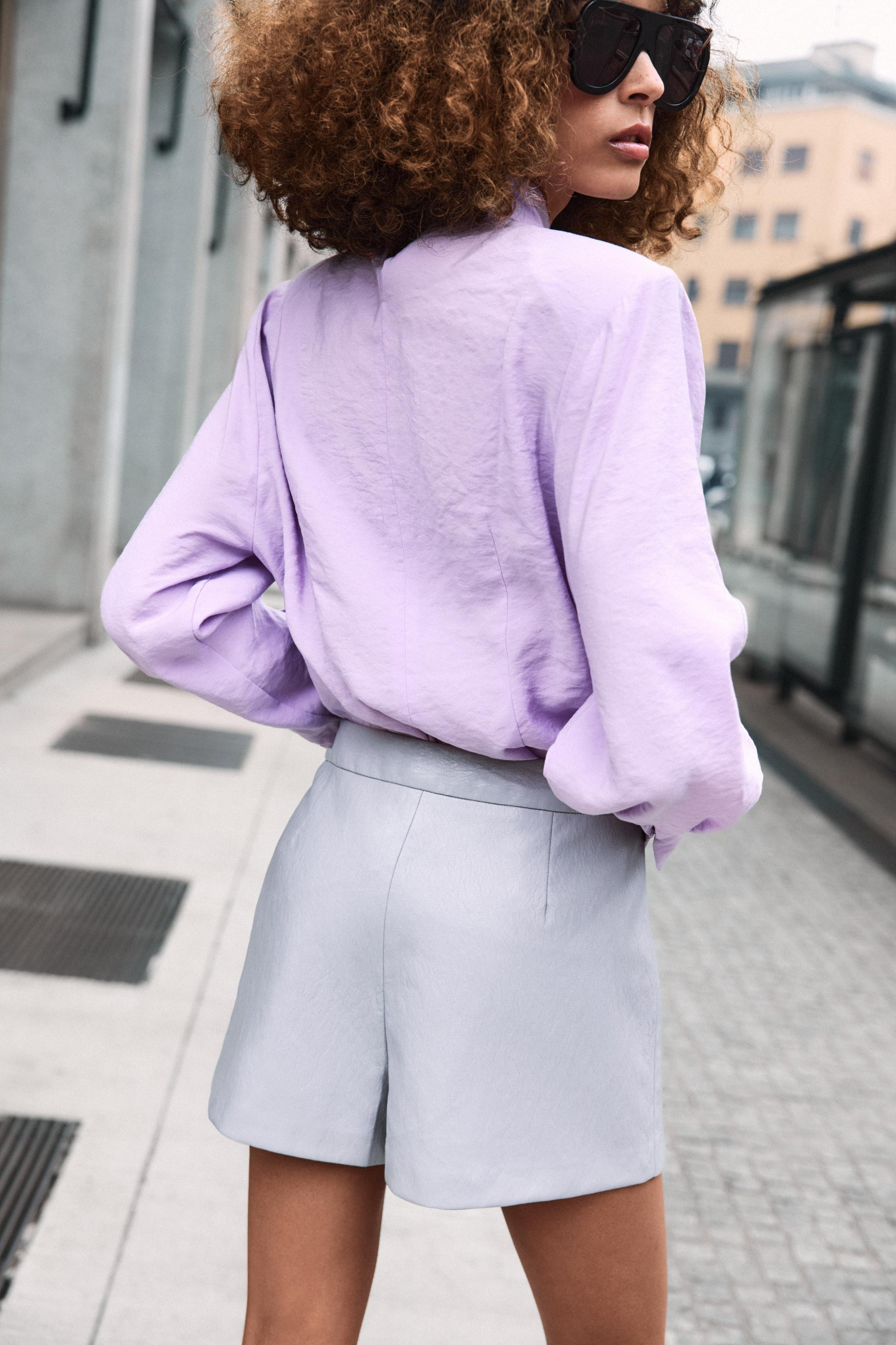 High collar blouse with V-neckline and long sleeves with shoulder pads. Back closure with opening... | Zara US