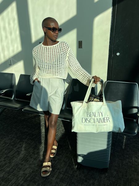Travel look! Open knit cream top, tailored 9 inch shorts, raffia double strap sandals, oversized cream tote bag, grey beis carry on bag and tortoise sunglasses. 

#LTKStyleTip #LTKTravel #LTKFindsUnder100