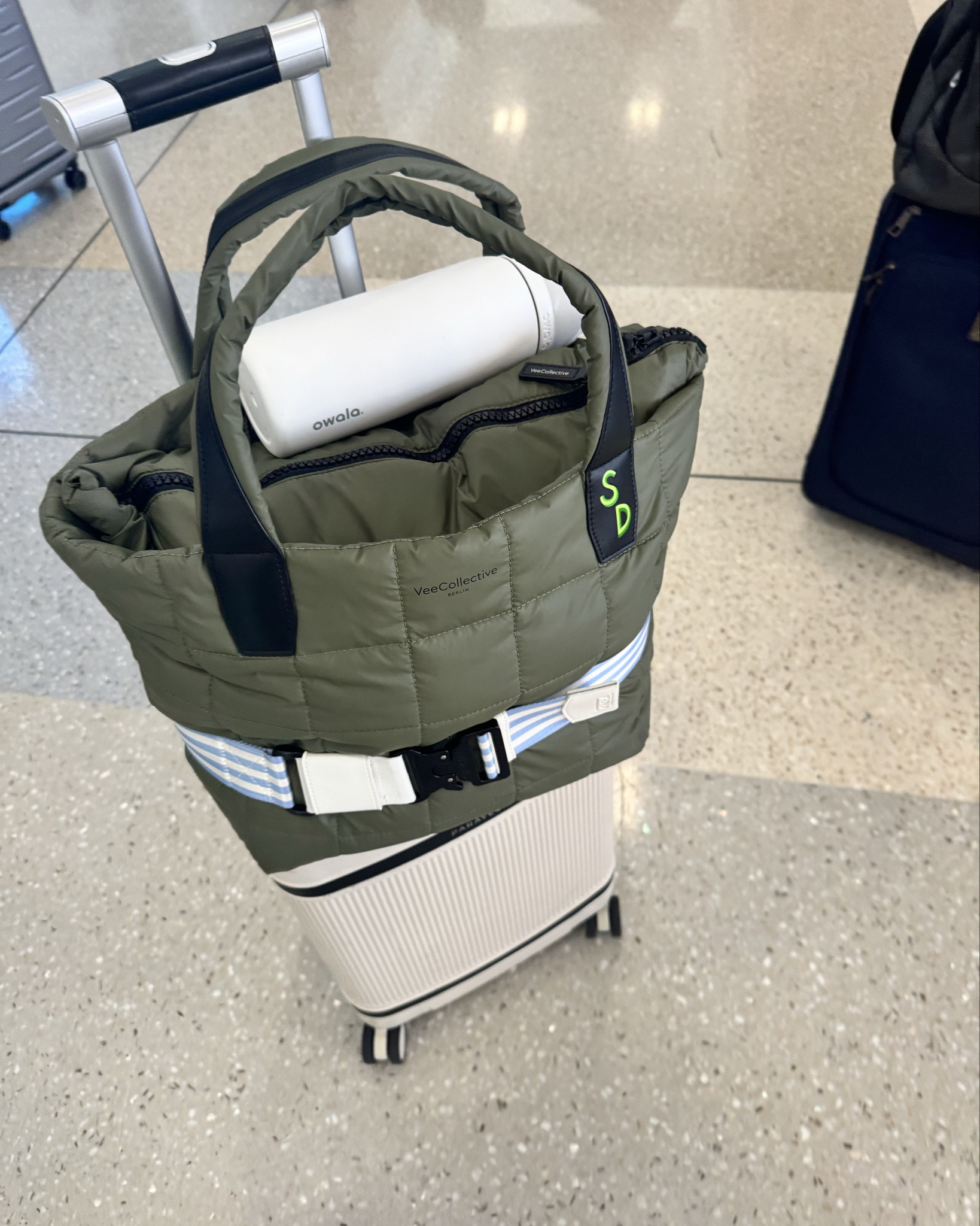 Love this Vee Collective Medium Porter tote. I received as a gift from the brand but love how lightweight it is. The straps don't fall off my shoulders and it holds so much! It has a separate laptop section so you can easily take it from work to the gym to the airport! It carries so much! It doesn't have a trolley strap, but an easy fix with a Cincha strap! 

The mushroom color (it's kind of like a greige with some pink undertones - last pic) and purplish color are on sale right now at Neiman Marcus. If you like the look of the bag, we also love the MZ Wallace Metro tote in medium. The Wuince bag linked is very similar to that one, but a lot cheaper! 