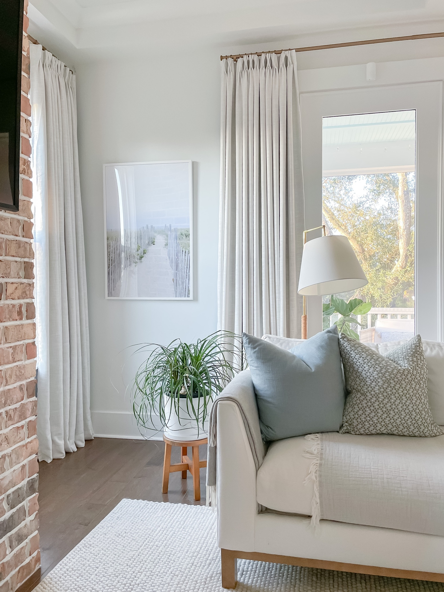 Coastal art in living room decorative sofa pillows floor lamp pinch pleat curtains 

#LTKFind