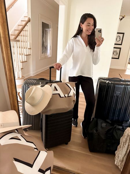 Kat Jamieson wears a white cotton sweatshirt, black sweatpants and sneakers to the airport for a travel day. Luggage, travel style, hat, tote, suitcase, bag. 

#LTKstyletip #LTKSeasonal #LTKtravel