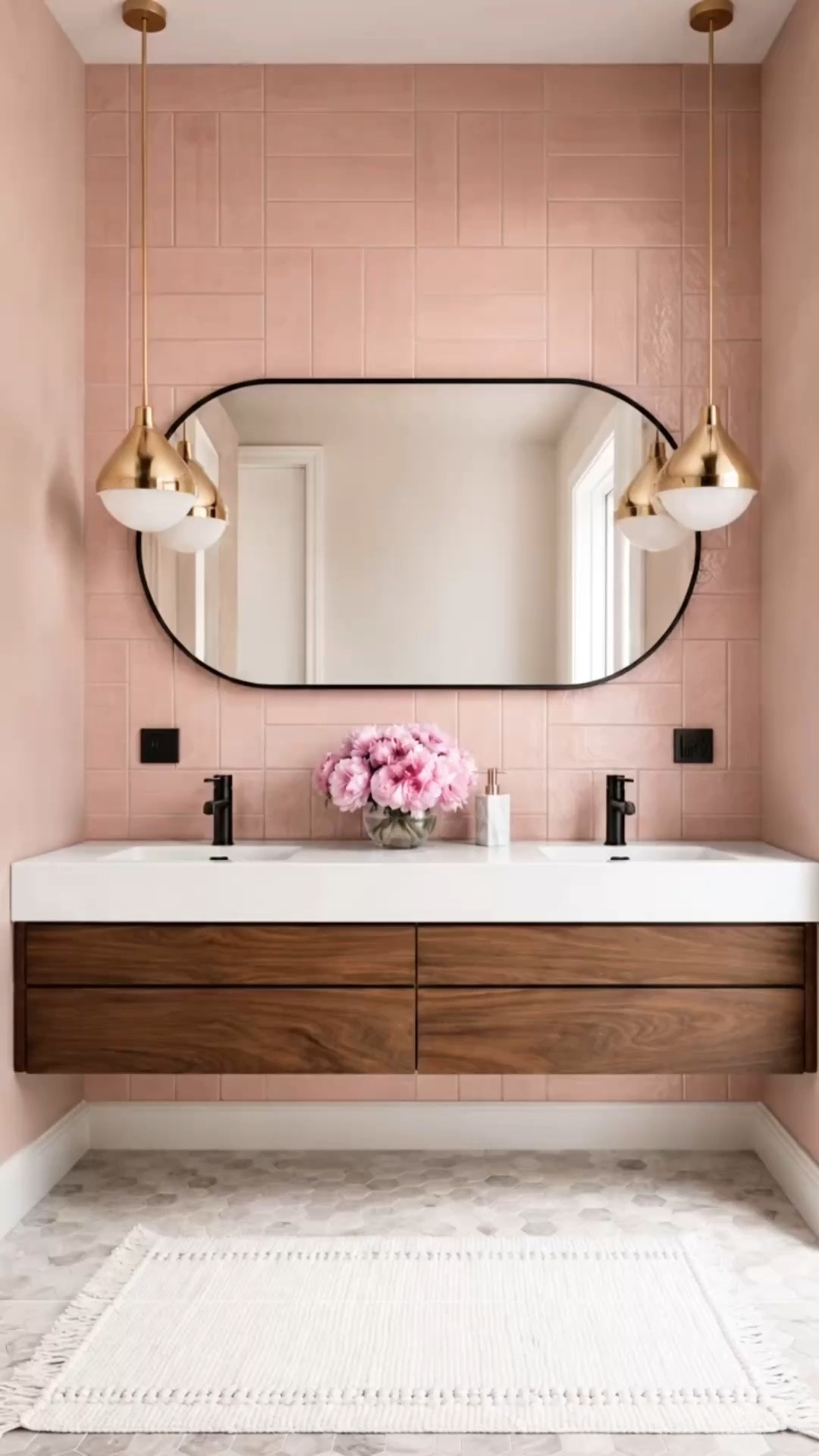 Just imagine unwinding in this master bath at the end of the day.

Glossy pink tile creates a soft, romantic atmosphere, while the Rejuvenation Esme walnut vanity brings warmth, rich wood grain, and furniture-inspired character. The curved black-framed mirror adds architectural contrast, and the brass pendant lights cast a gentle glow across the room.

A calming retreat designed to help you relax, reset, and recharge.

#MasterBathroom #BathroomDesign #PinkBathroom #PinkTile #BathroomVanity #FloatingVanity #WallMountedVanity #WalnutVanity #Rejuvenation #EsmeVanity #DoubleVanity #BrassPendant #BathroomLighting #BathroomMirror #ModernClassic #RomanticInteriors #LuxuryBathroom #LTKHome #LTKdayinmylife #LTKSaleAlert

#LTKdayinmylife #LTKHome #LTKSaleAlert