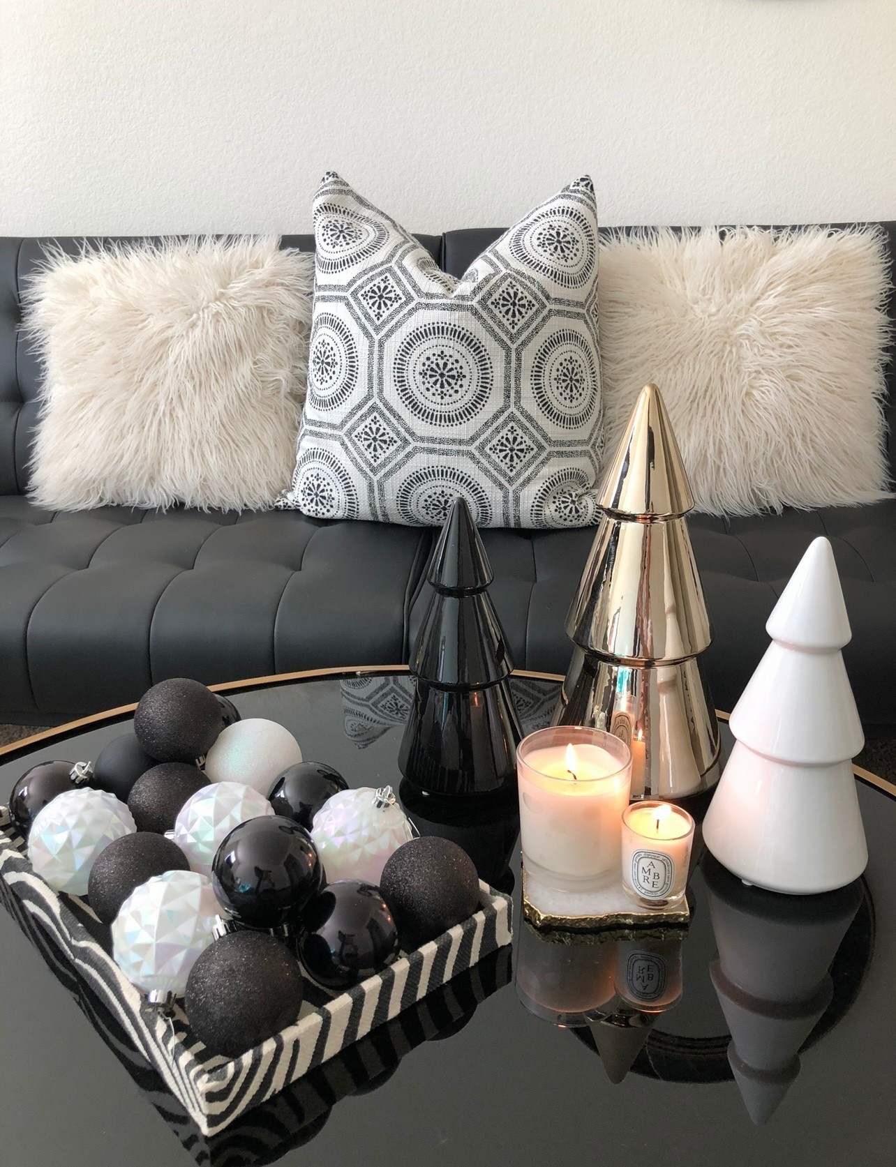 Elevate your holiday style with chic black and white Christmas decor. Perfect inspiration for a modern Christmas aesthetic, neutral holiday decor, monochrome Christmas styling, and elegant winter home decor. This modern living room features a sleek black tufted sofa paired with cozy faux-fur pillows, glossy ceramic Christmas trees in black, white, and gold, and a stylish tray filled with matte and iridescent black-and-white ornaments. Soft candlelight adds a warm, minimalist touch. 

#LTKHoliday #LTKSeasonal #LTKHome
