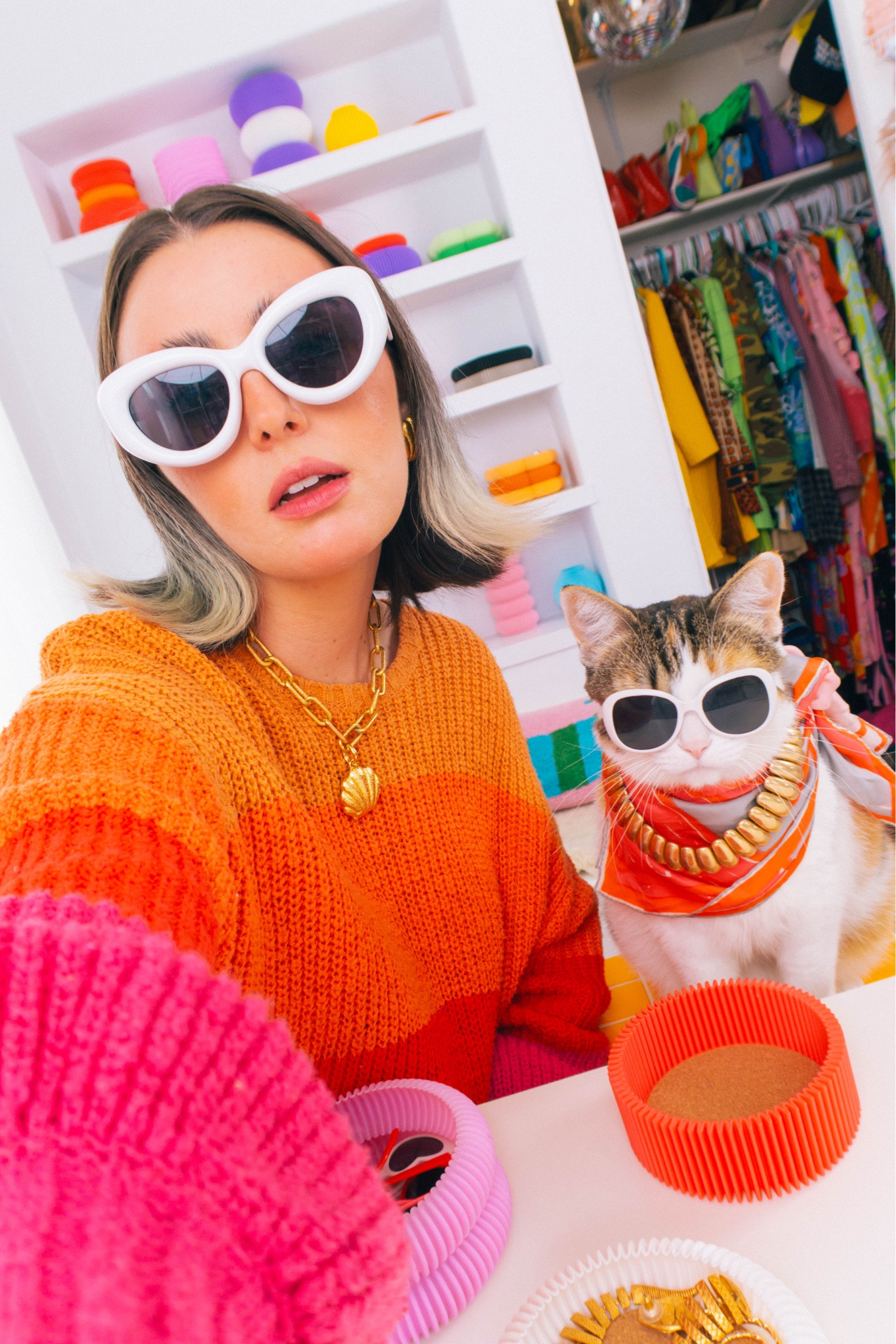 finally chilly enough to start wearing sweaters!! I love summer but I’ve had enough heat!! I am ready to enjoy cozy weather, fluffy blankets, and all the pumpkin spice flavored everything  🎃✨

Champagne wears a rainbow orange red and pink knitted sweater with gold seashell necklace and earrings. With chunky white retro sunglasses. Pony wears a abstract orange scarf with a chunky gold necklace and white retro sunglasses.
#grwm #ootd #cat #cats #catlover #catlife #catmemes #jewelry #jewellery #fashion #maximalist #maximalism #dopaminedressing 