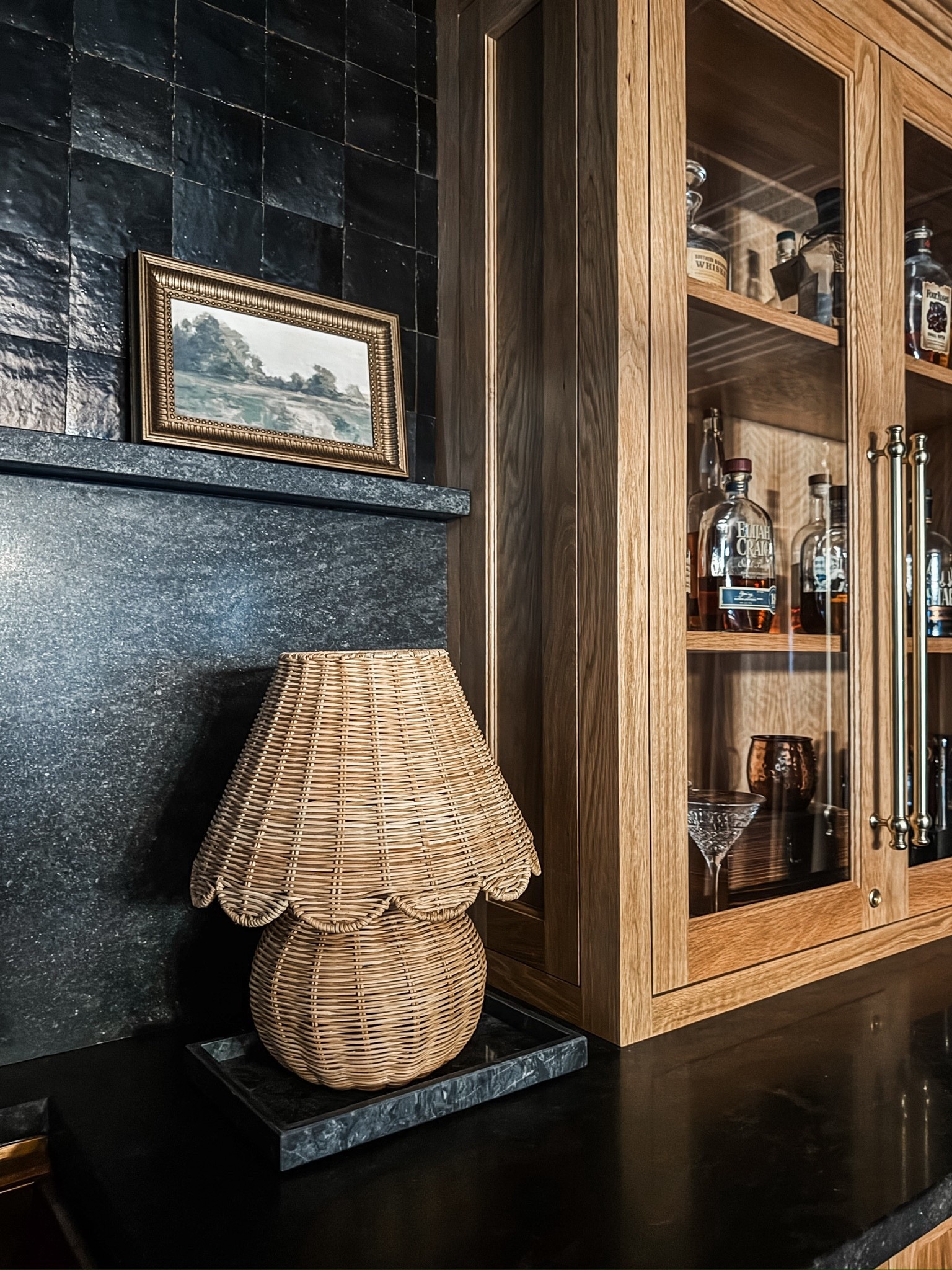 A perfect balance of cozy and refined ✨ The rattan accent lamp softens the look of the black stone backsplash, while the custom-style wood cabinets, glass-front storage, bronze faucet, stone counters, and under-counter beverage fridge elevate this bar setup into something truly timeless. Every detail matters.

#interiordetails #homebarstyle #classicdesign #layeredtextures #eanesinteriors


#LTKHome #LTKOver40 #LTKvlog