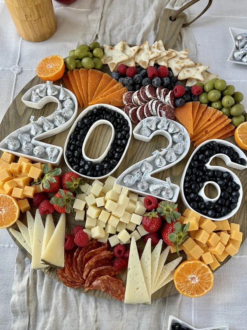 This is the ultimate New Year’s Eve charcuterie board. Always a crowd-pleaser, it brings together sweet treats, savory bites, and takes less than 25 minutes to assemble. I love using silver and black candies for a celebratory touch. Fill the candy in 2026 number dishes (see below for other options) and you have the beautiful NYE starter.

#LTKGiftGuide #LTKHoliday